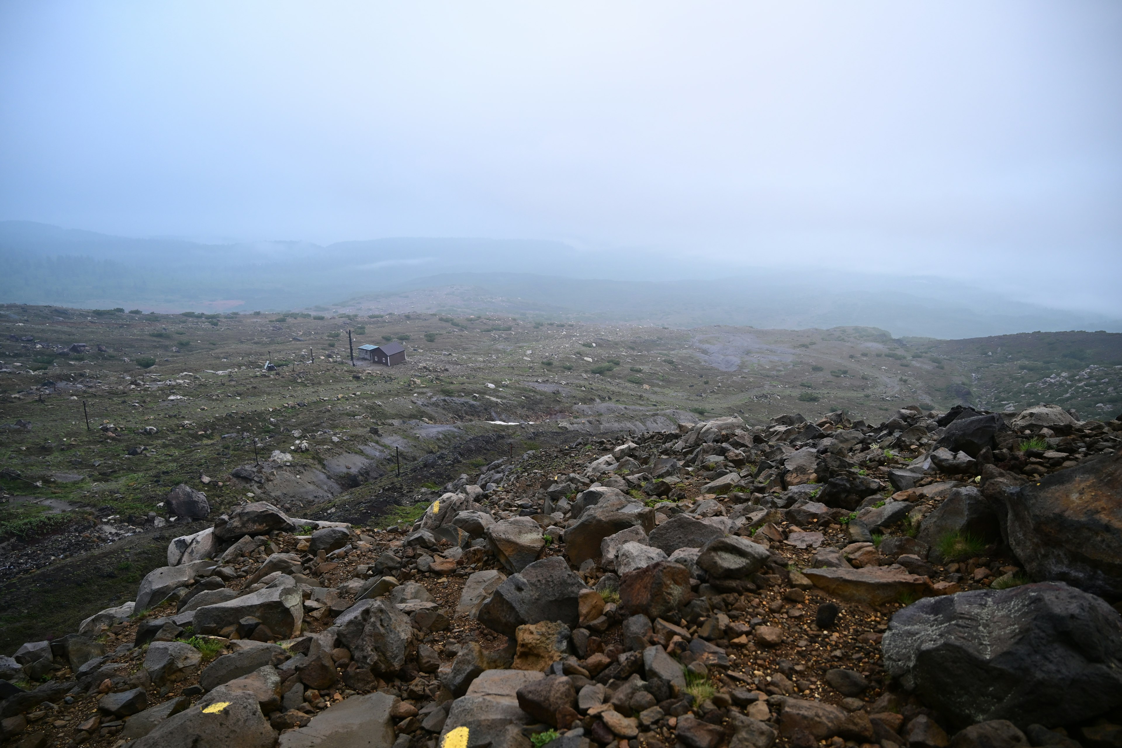 霧がかかった山の風景と岩だらけの地面