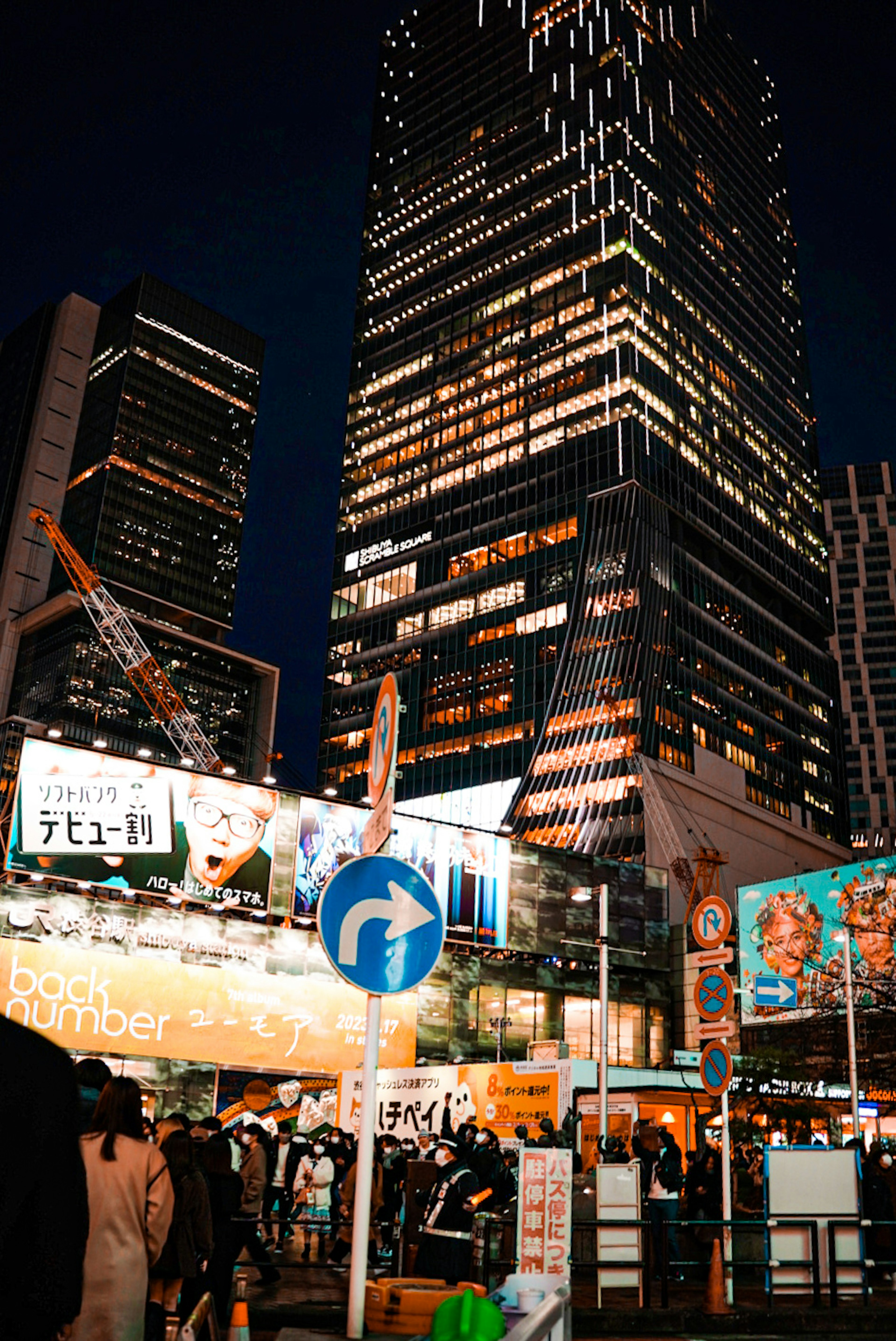 Night cityscape featuring illuminated skyscrapers and traffic signs