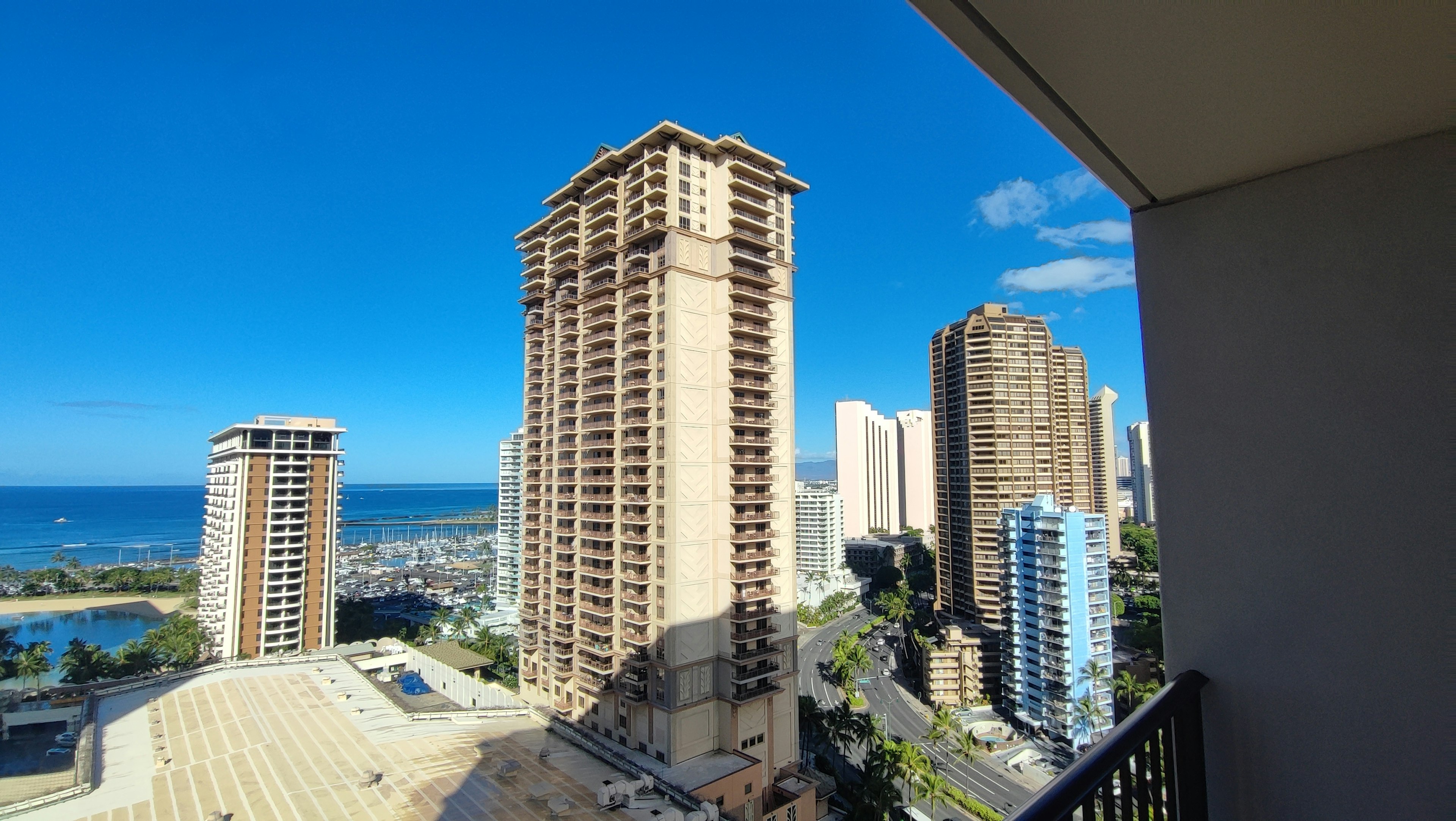 View of tall buildings under a clear blue sky with ocean in the background