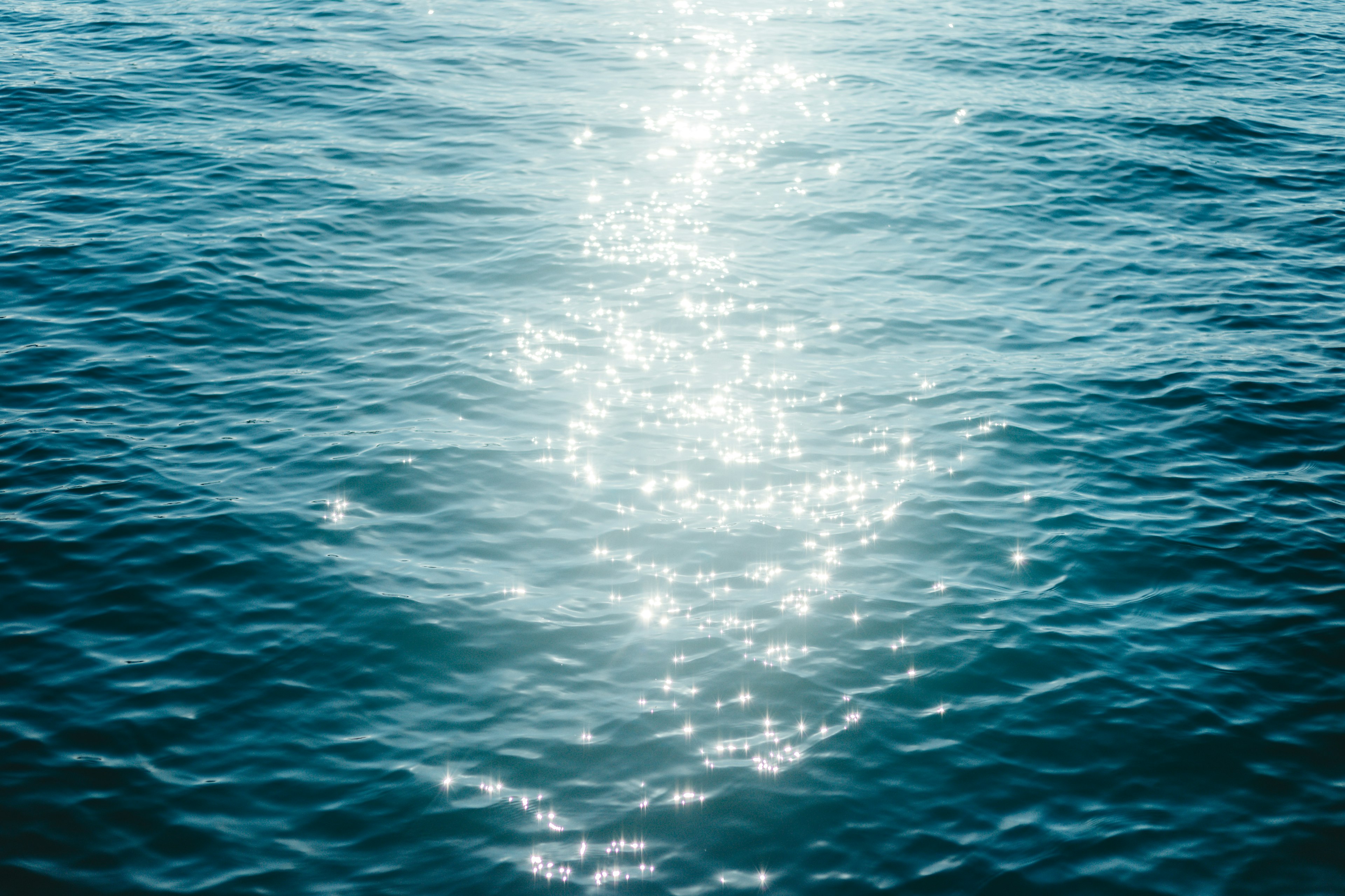 Hermosa escena de la luz del sol reflejándose en la superficie del agua azul del océano