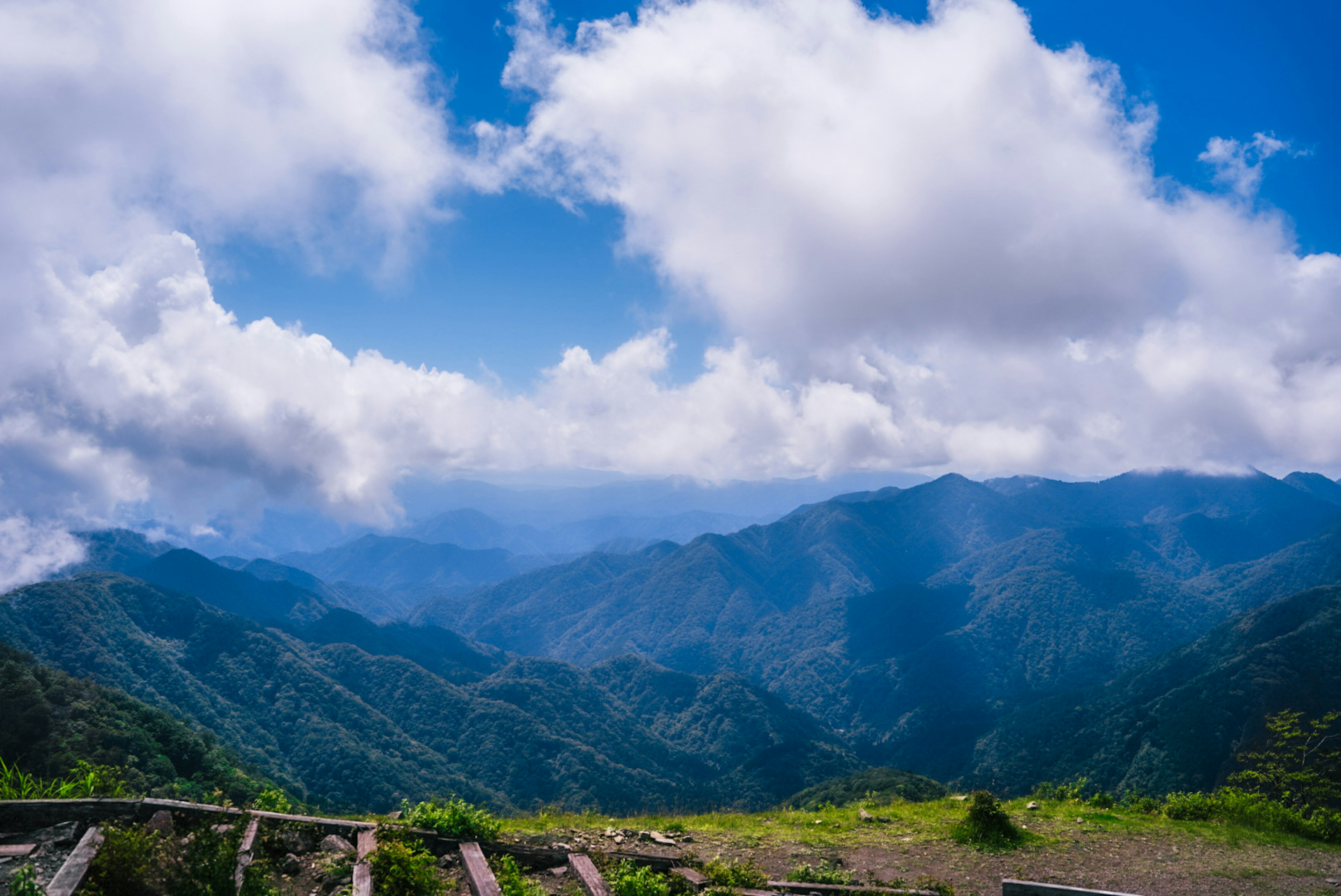 Vista escénica de montañas bajo un cielo azul con nubes blancas