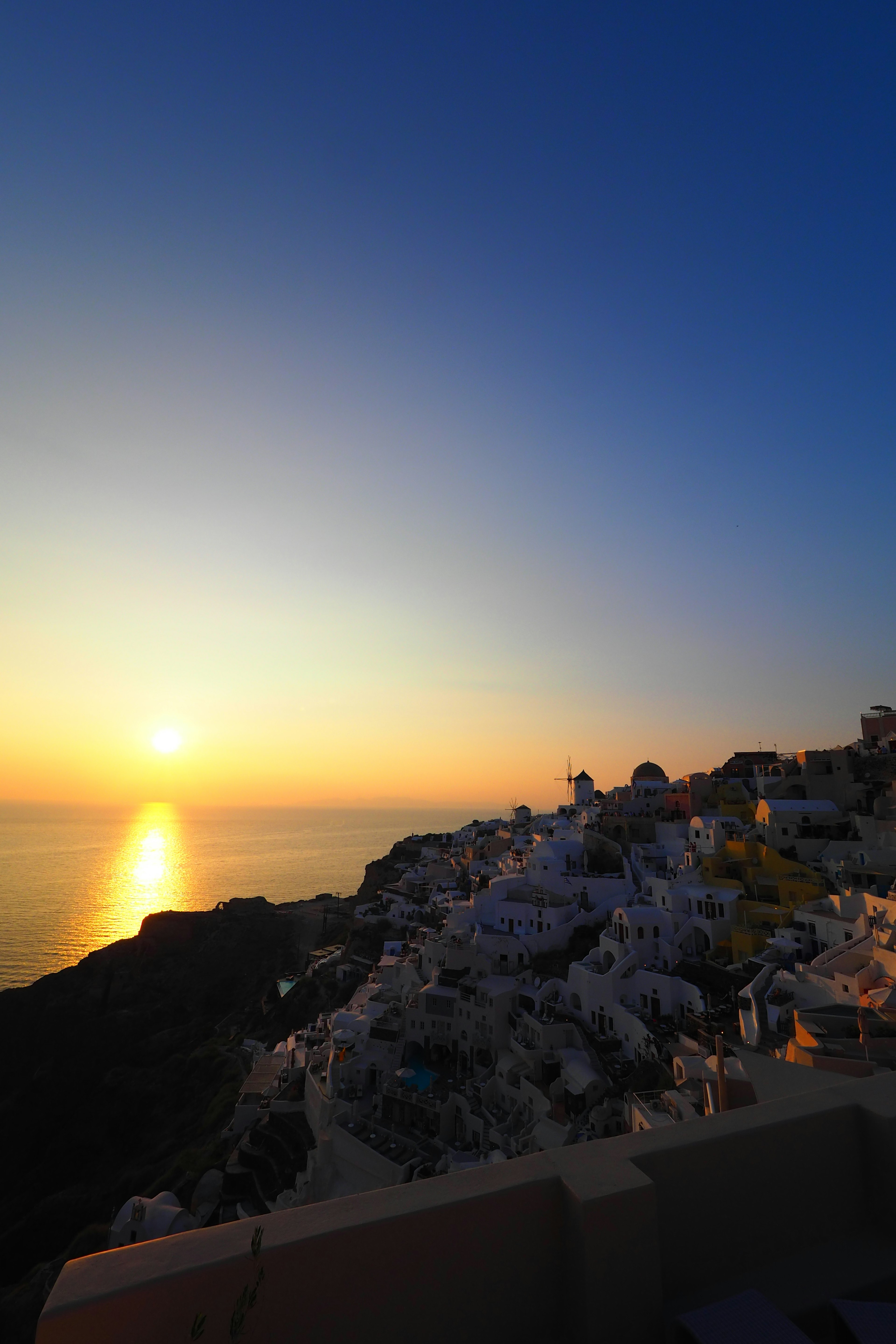 美しい夕日が海に沈む景色 白い建物が並ぶサントリーニの風景