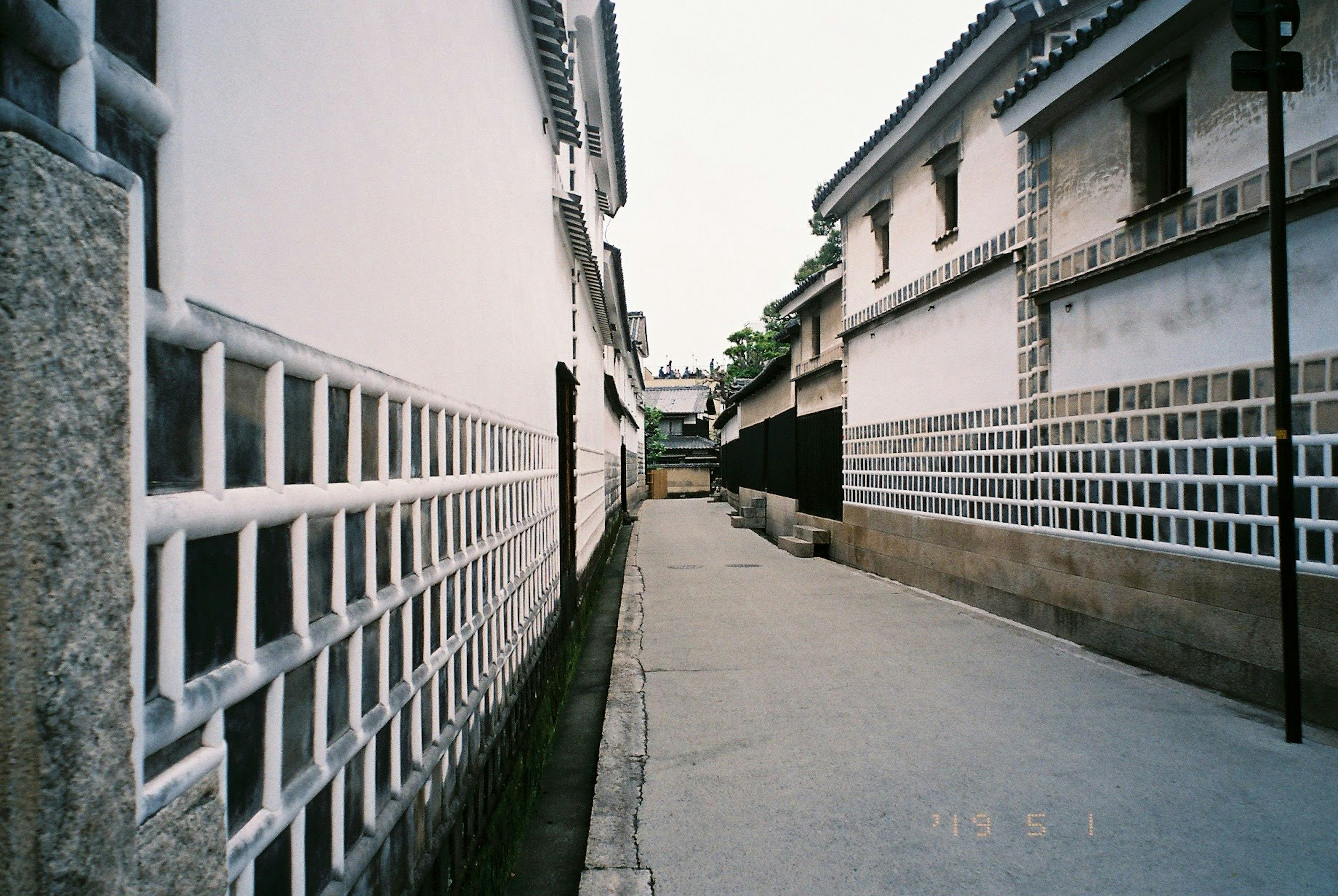 狹窄的街道，兩旁是白牆建築和石頭鋪路