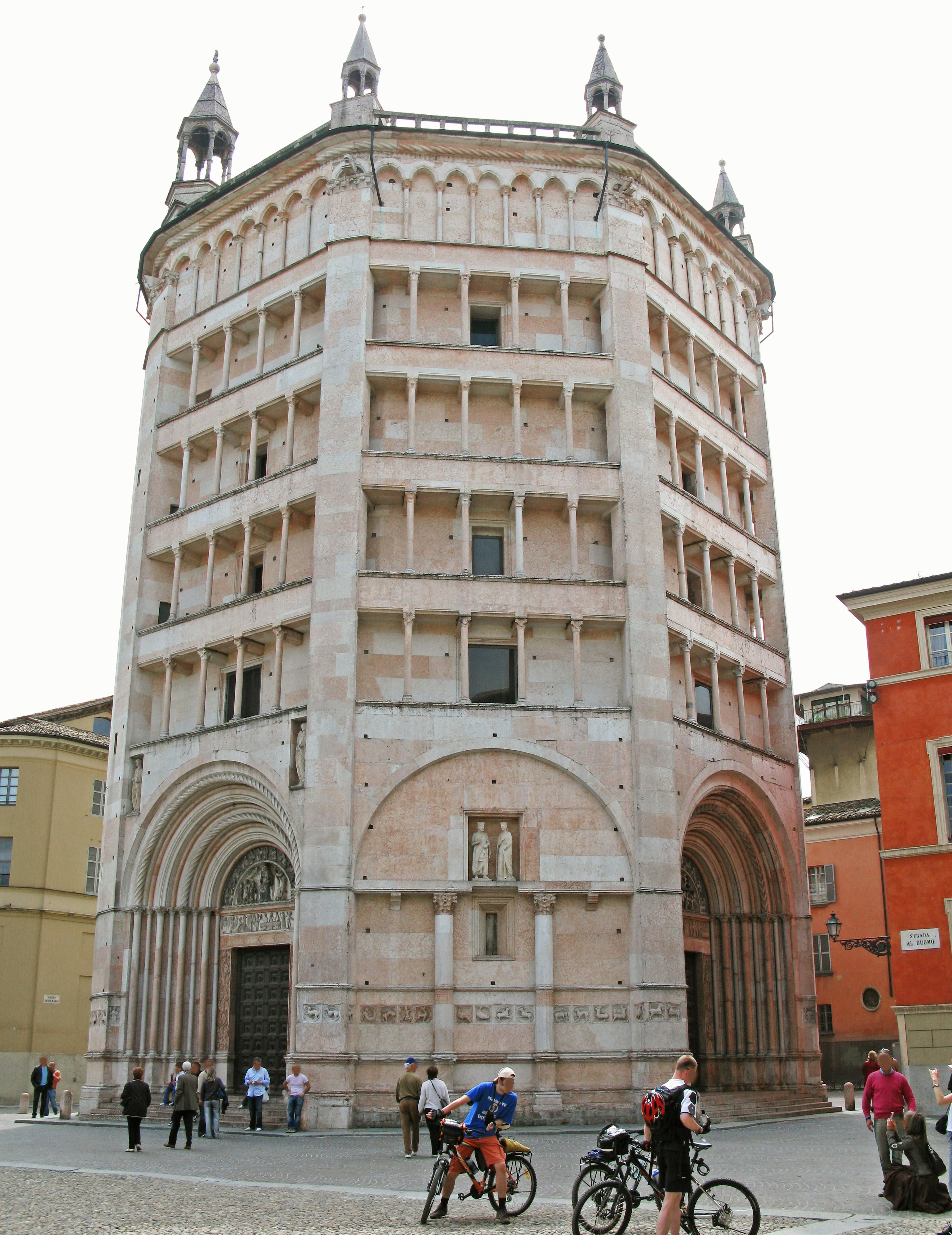 The beautiful exterior of the Baptistery of Parma with surrounding people