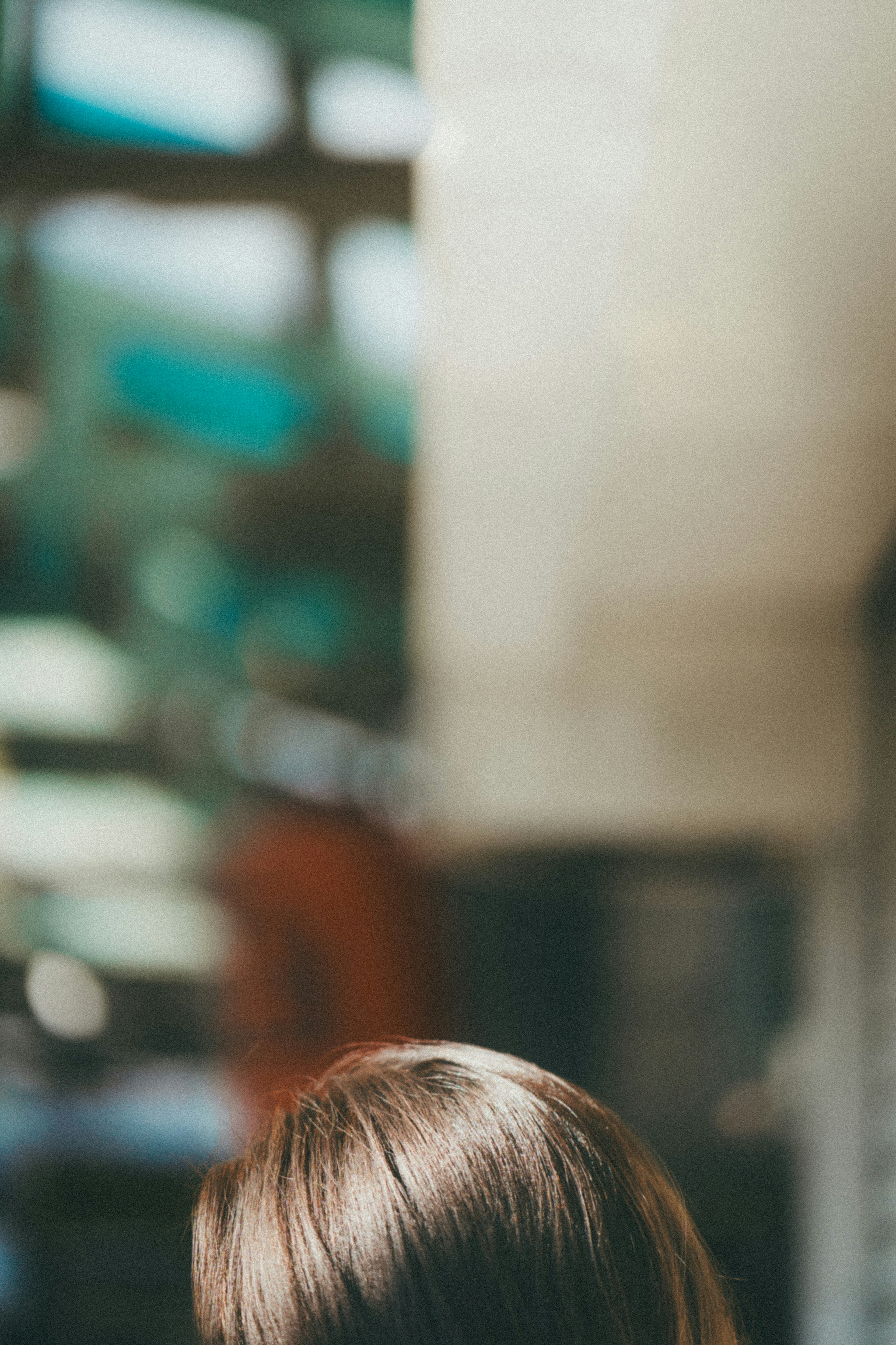 Back view of a person with hair blurred interior colors in the background