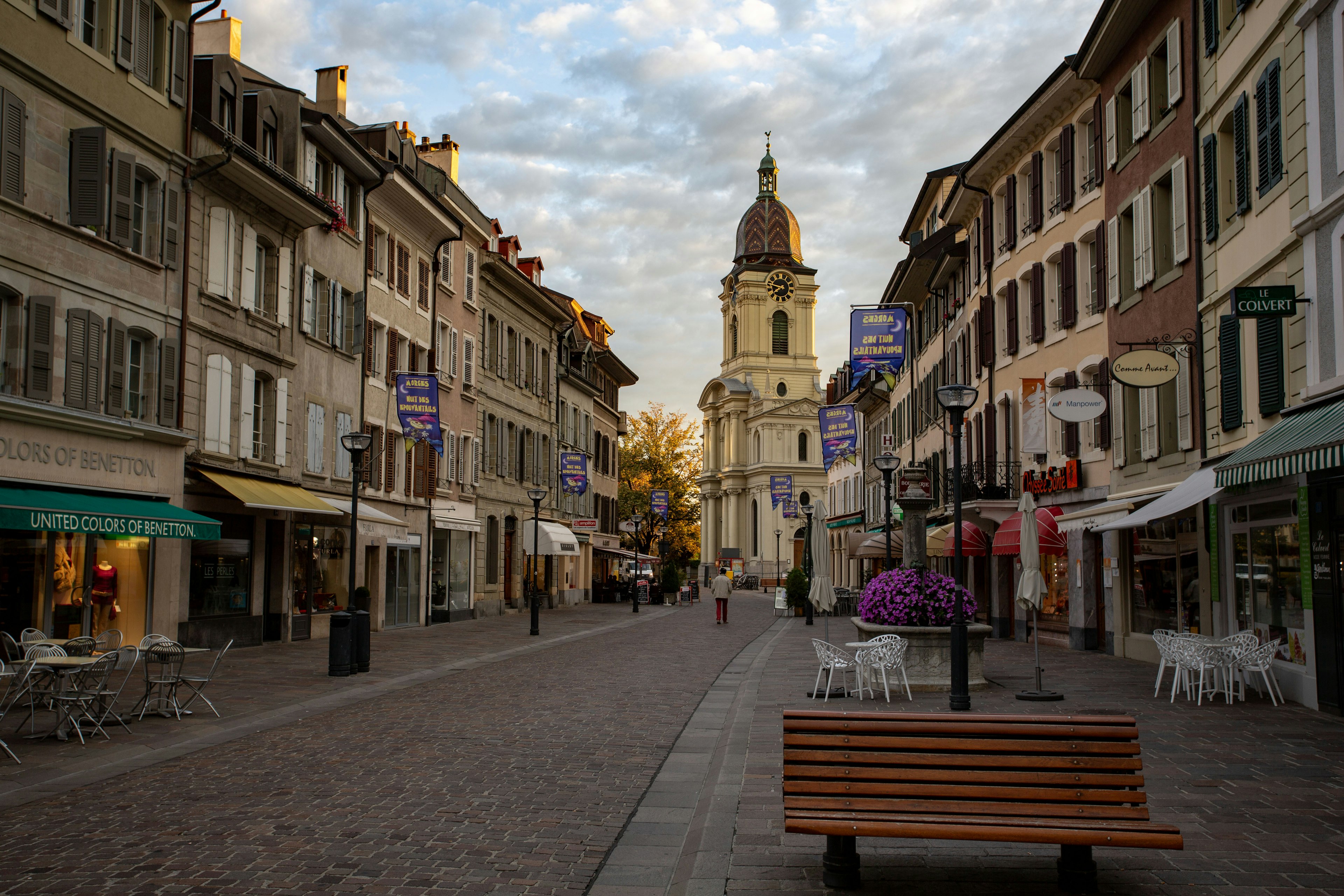 Historic street featuring a church and a wooden bench