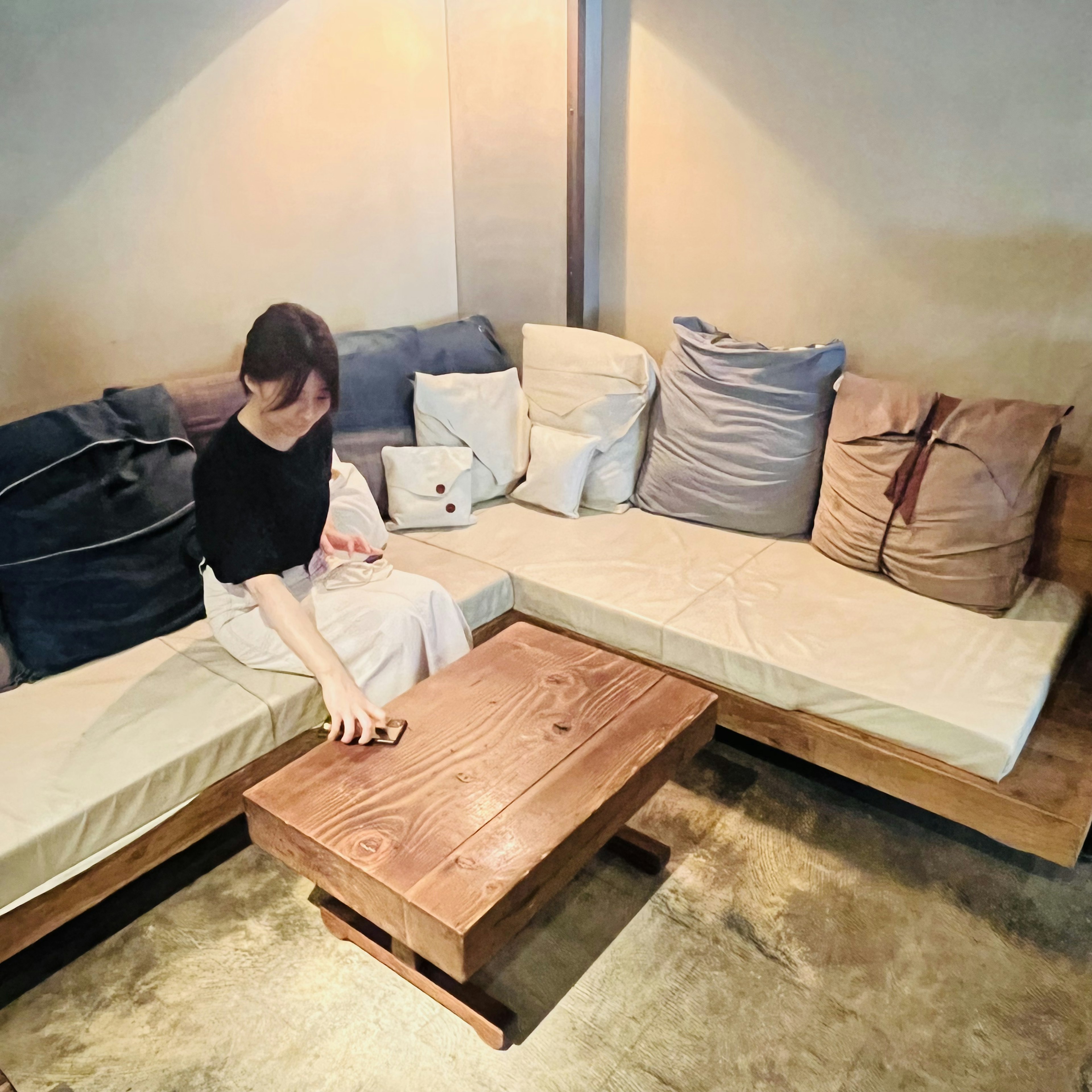 Une femme assise sur un canapé avec des coussins dans un intérieur de café