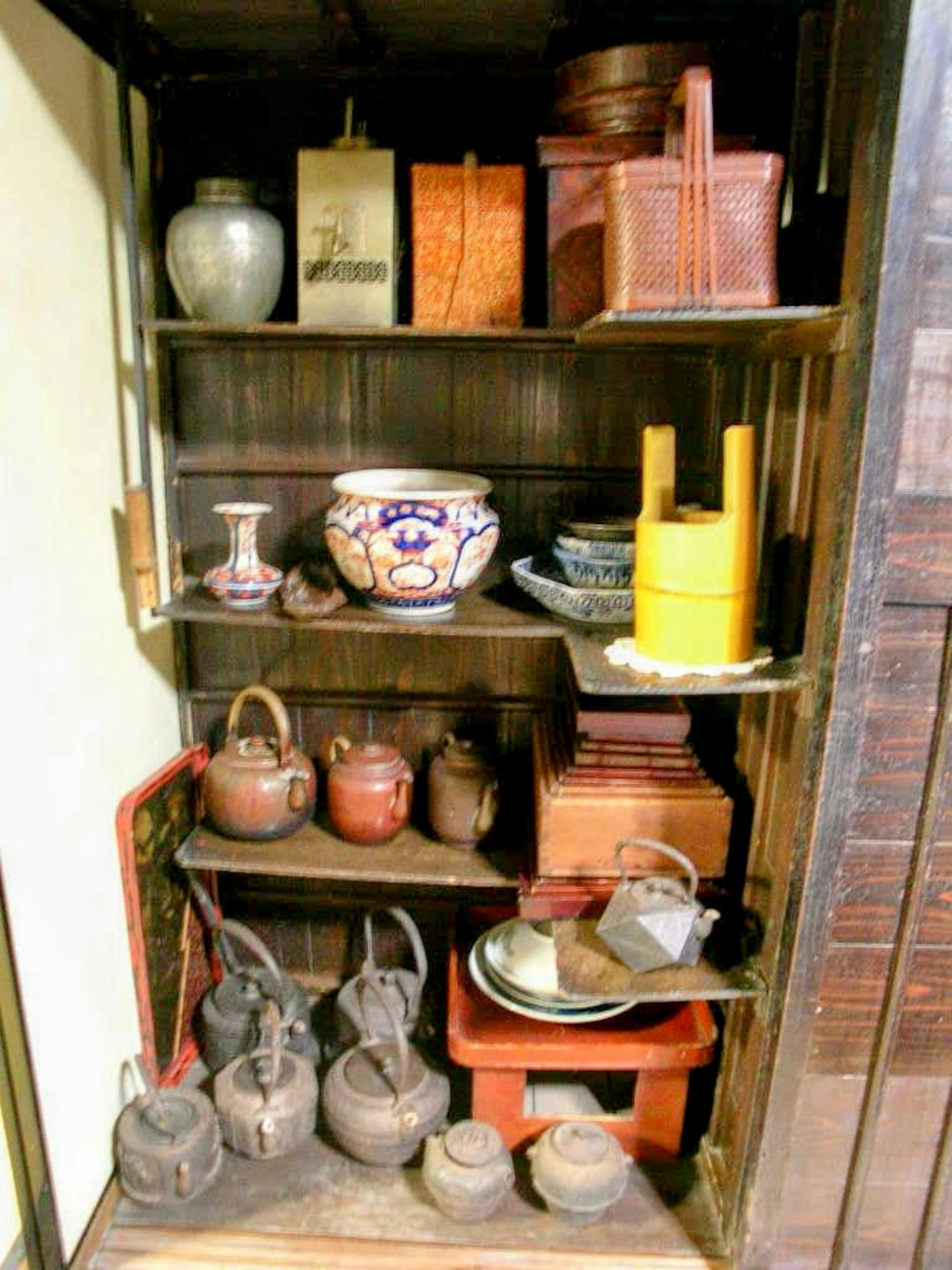 Collection of traditional pottery and teapots displayed on shelves