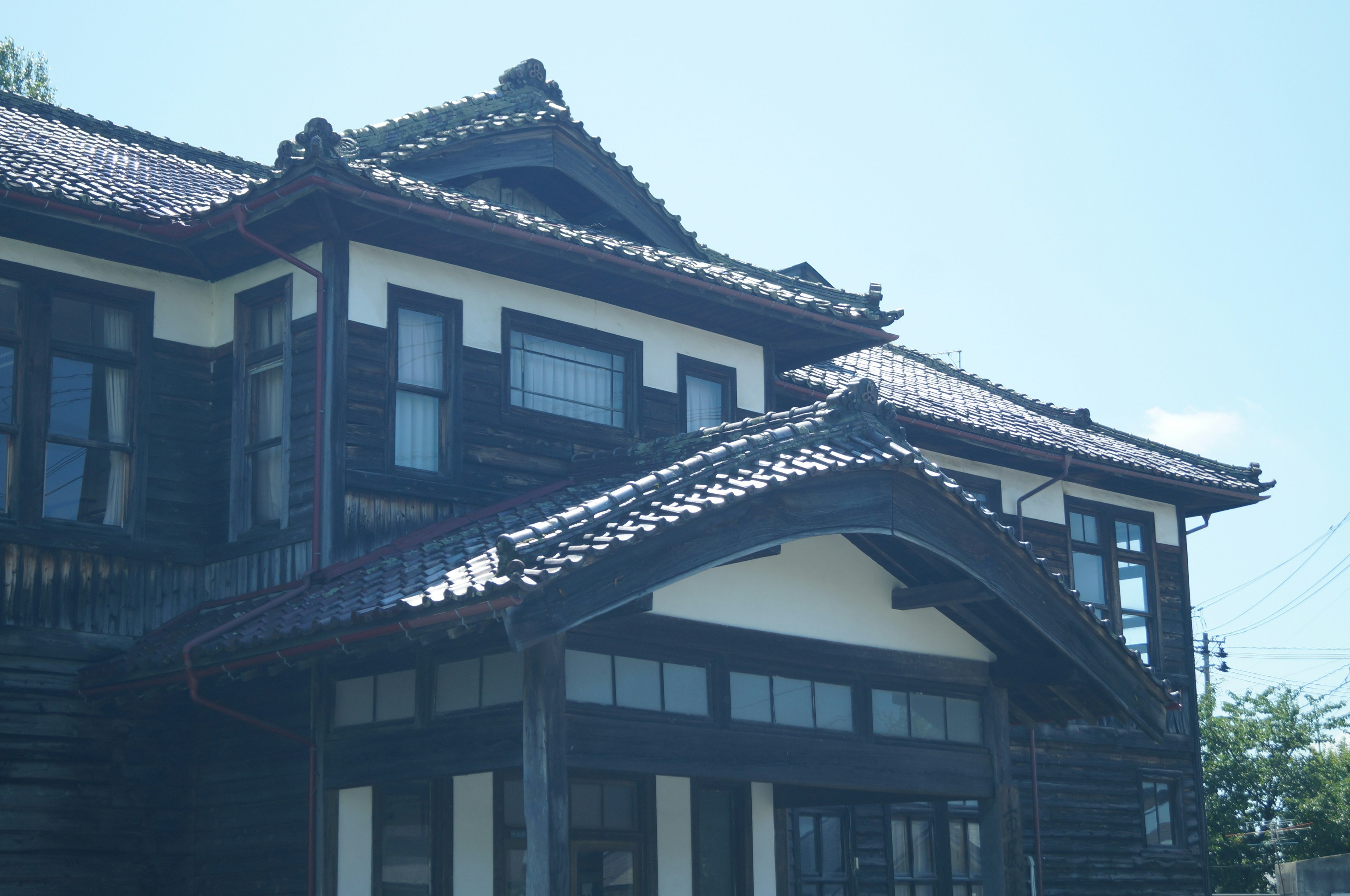 Teil eines traditionellen japanischen Hauses mit dunklem Holz und Ziegeldach