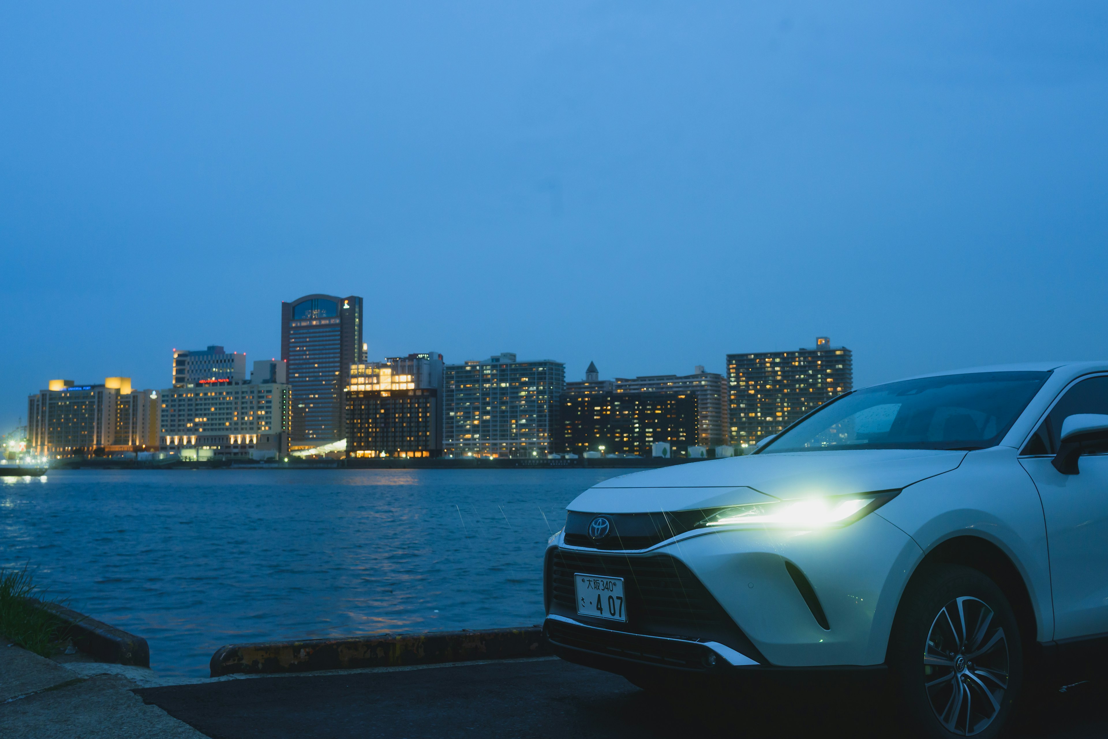 夜間城市景觀和停在水邊的白色汽車