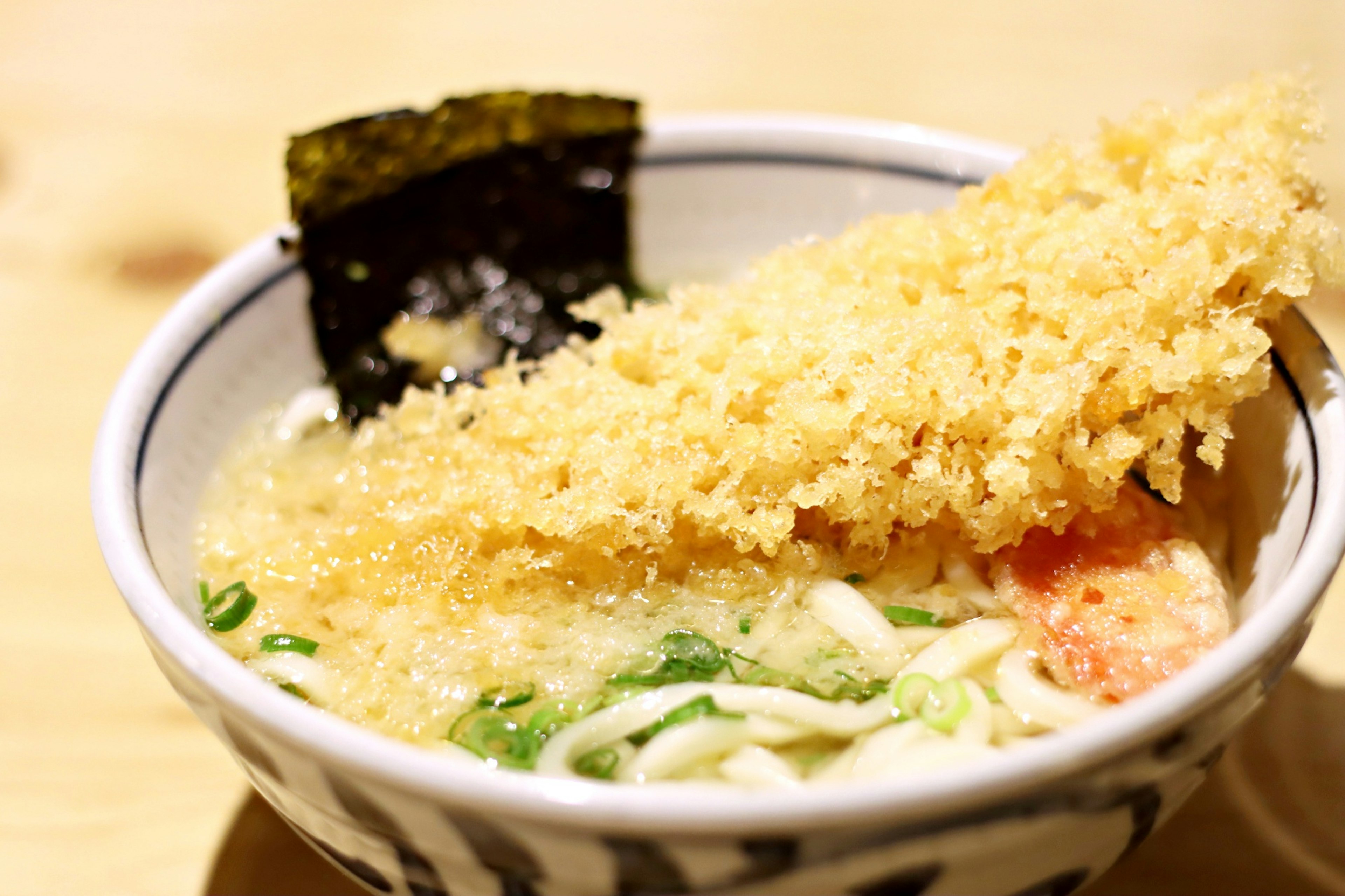 Bowl of ramen topped with crispy fried food and seaweed