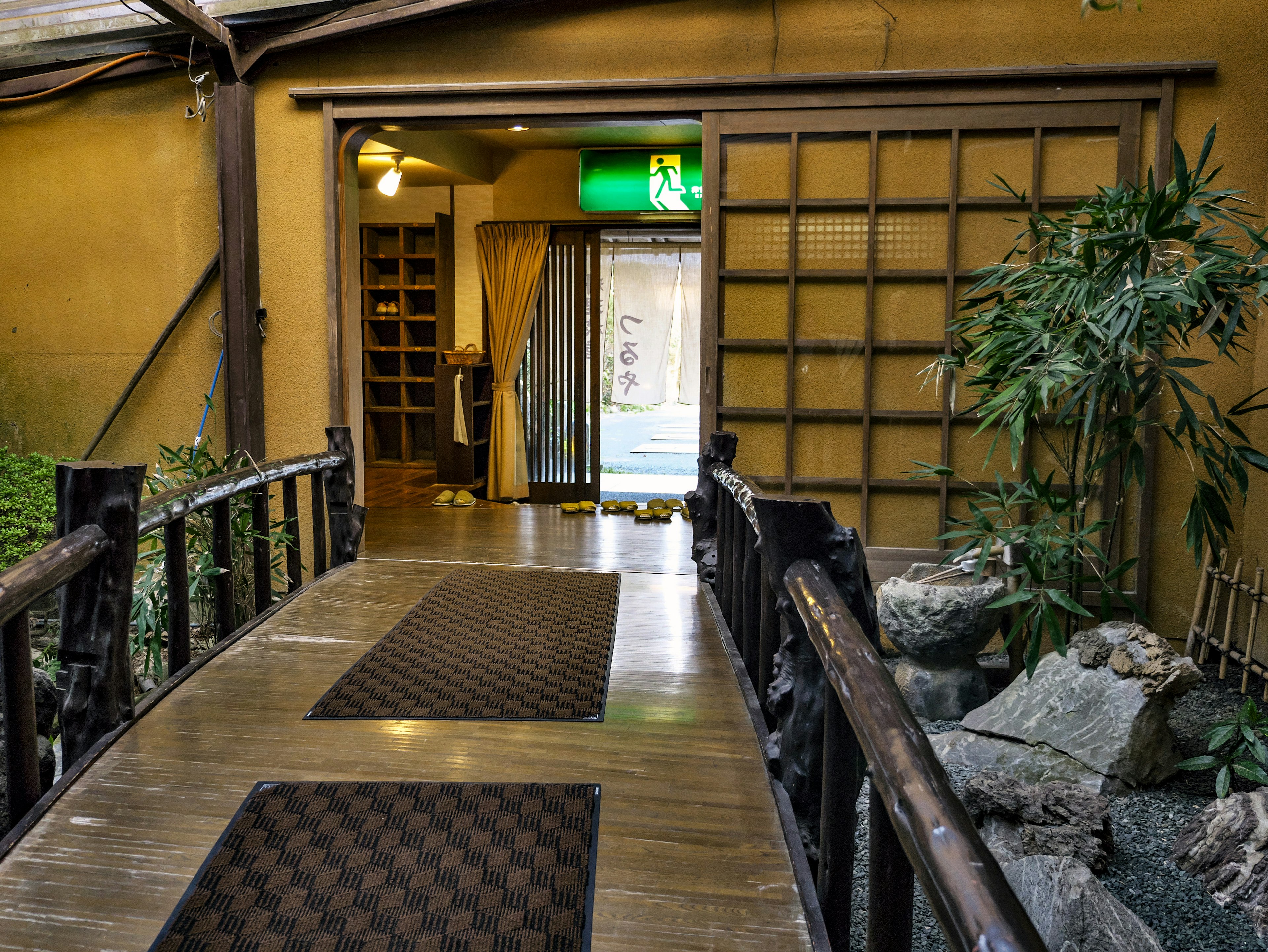 Vista d'ingresso di un percorso con un ponte, bamboo e pietra in un design giapponese