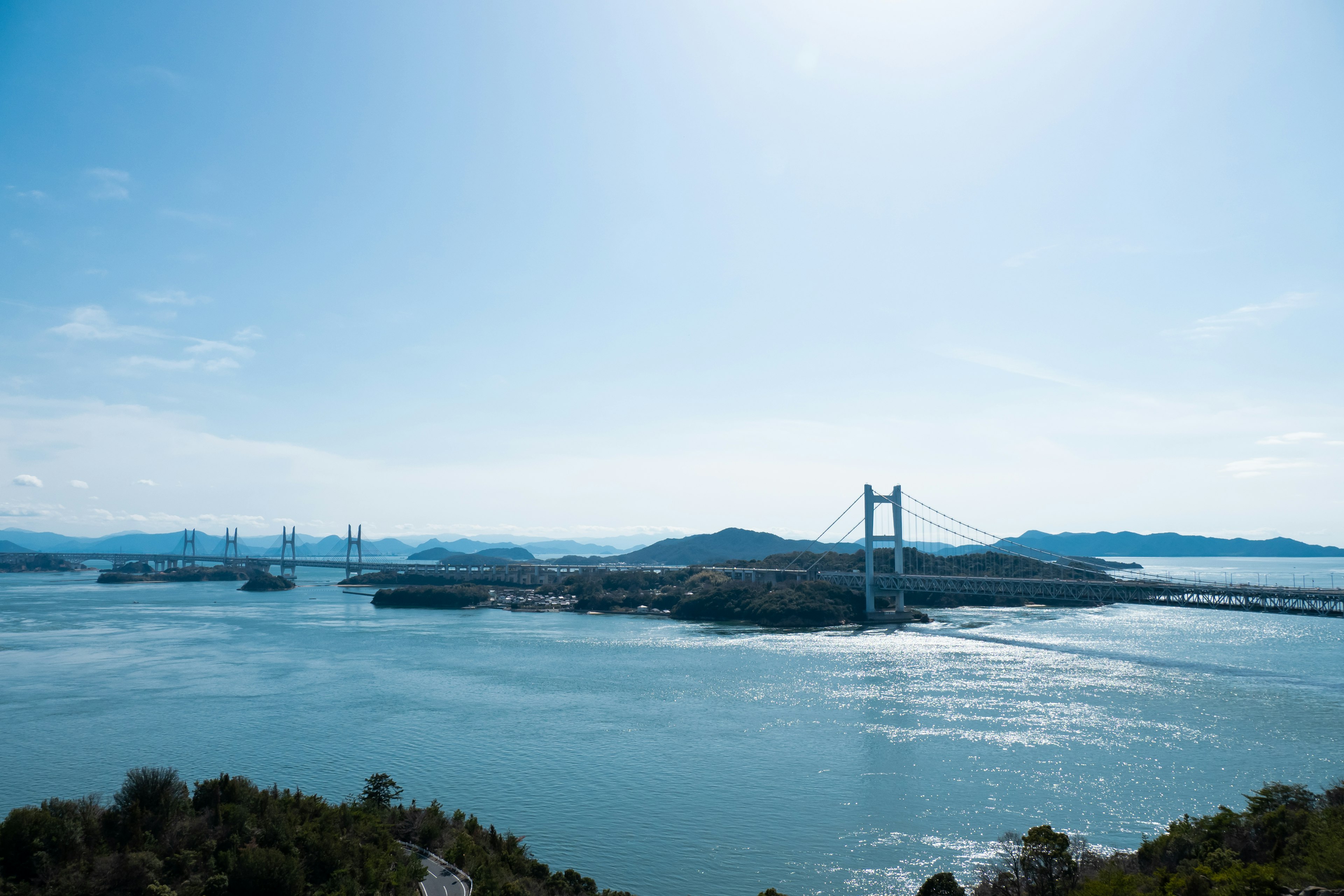 Vista escénica de un puente e islas rodeadas de cielo y agua azul