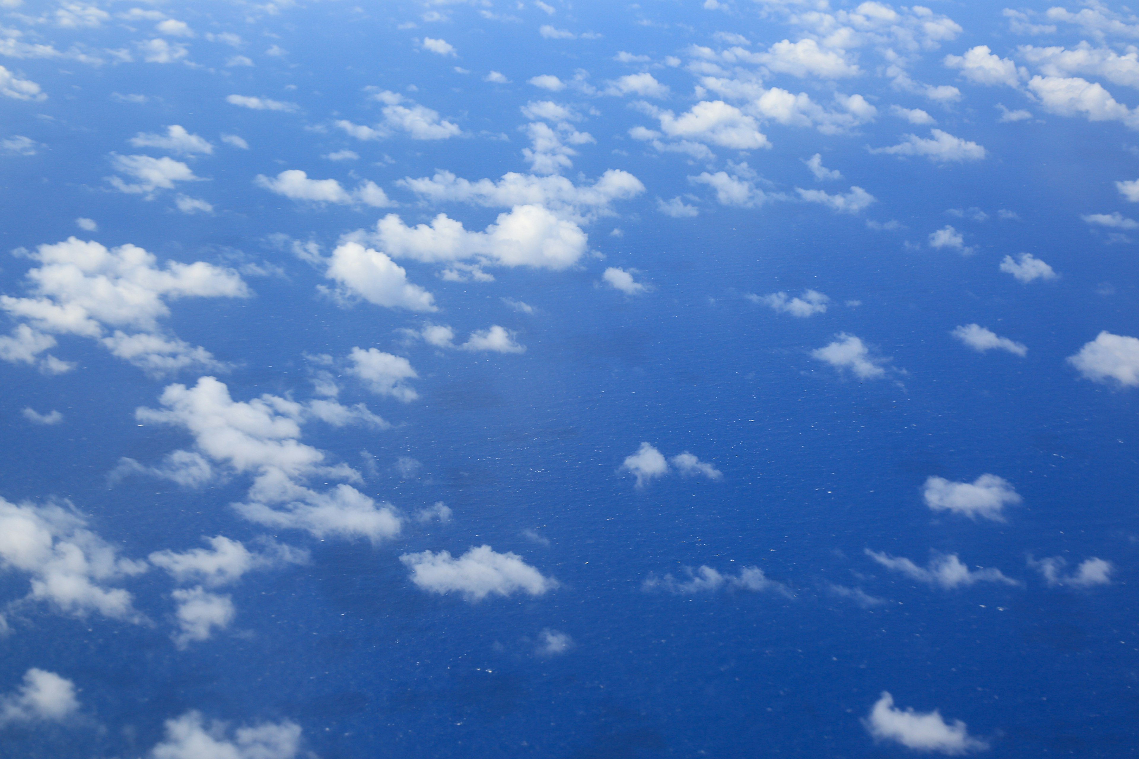 Weites blaues Meer mit verstreuten weißen Wolken