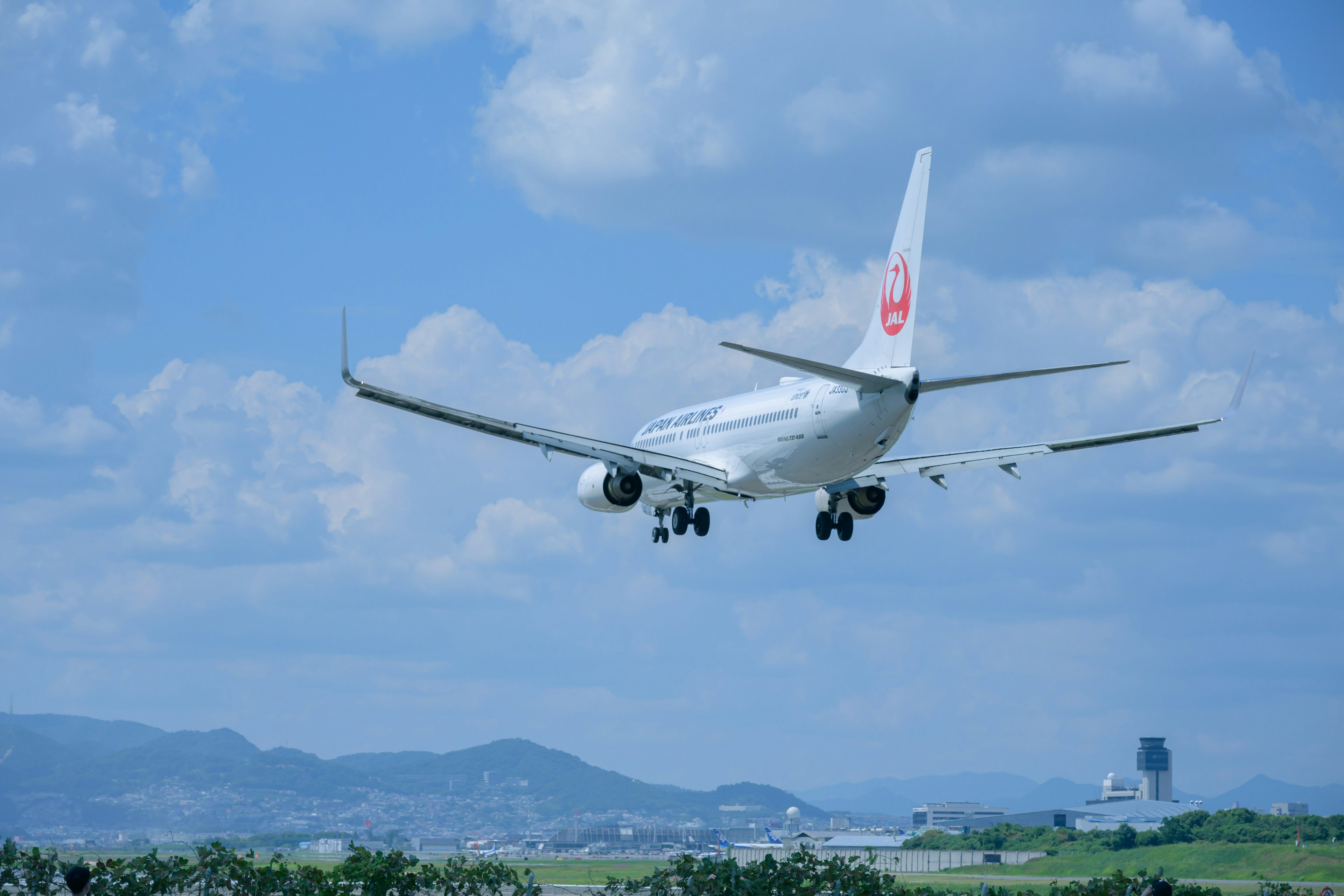 Avion de ligne Japan Airlines atterrissant sous un ciel bleu