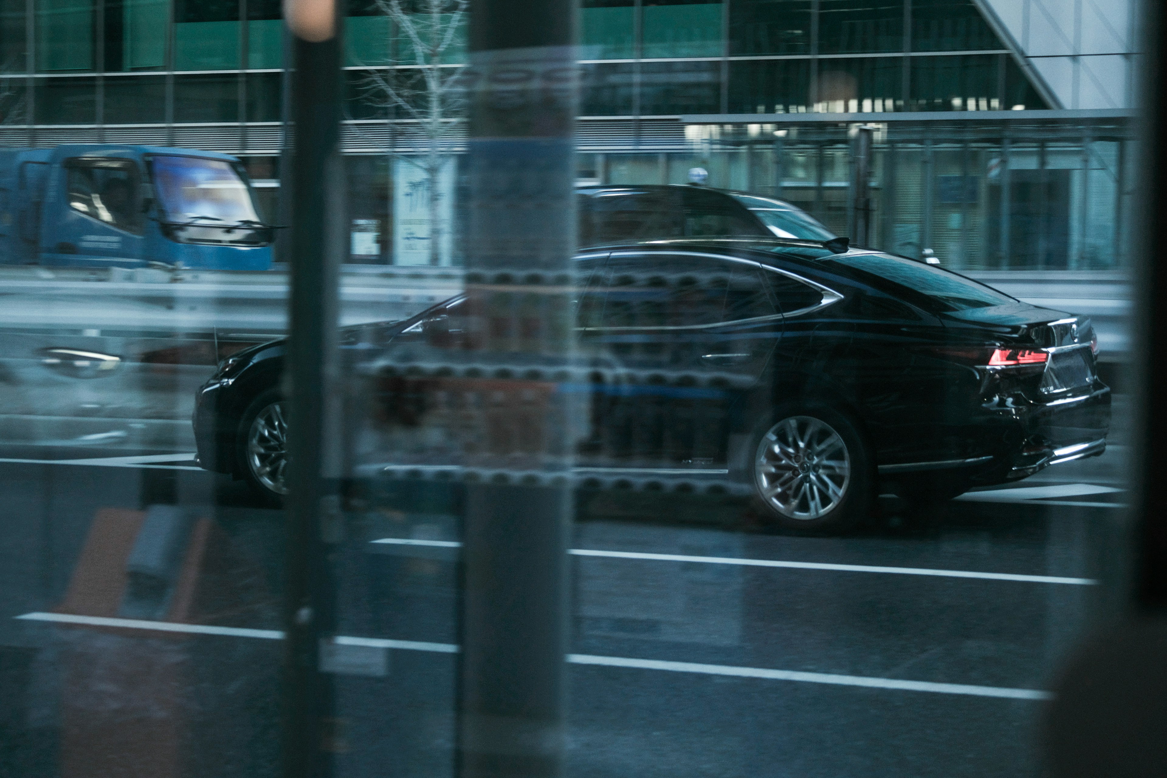 A black car driving on an urban street