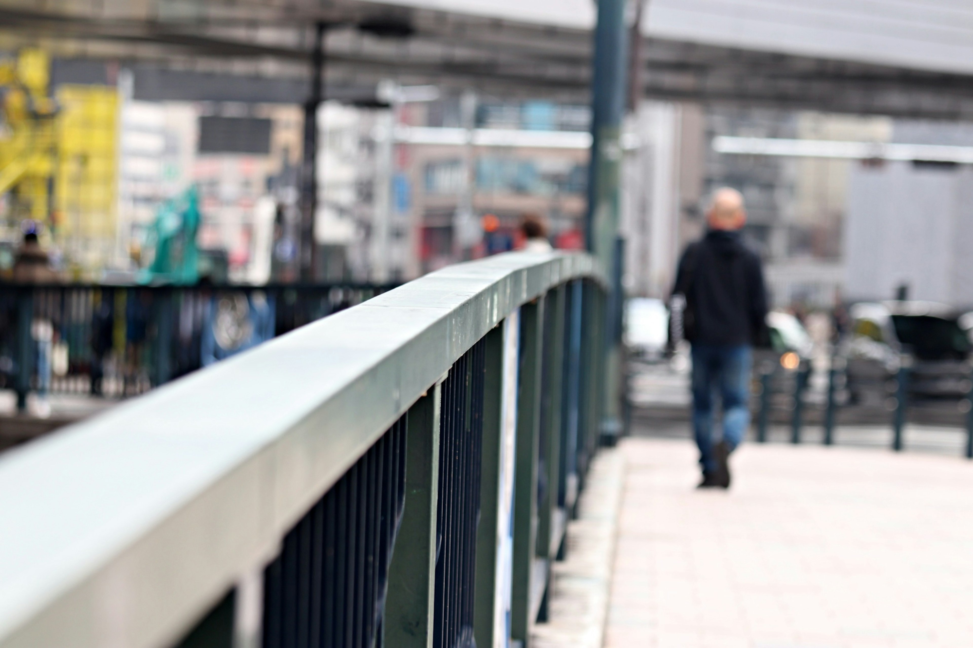 Cityscape featuring a bridge railing and a pedestrian