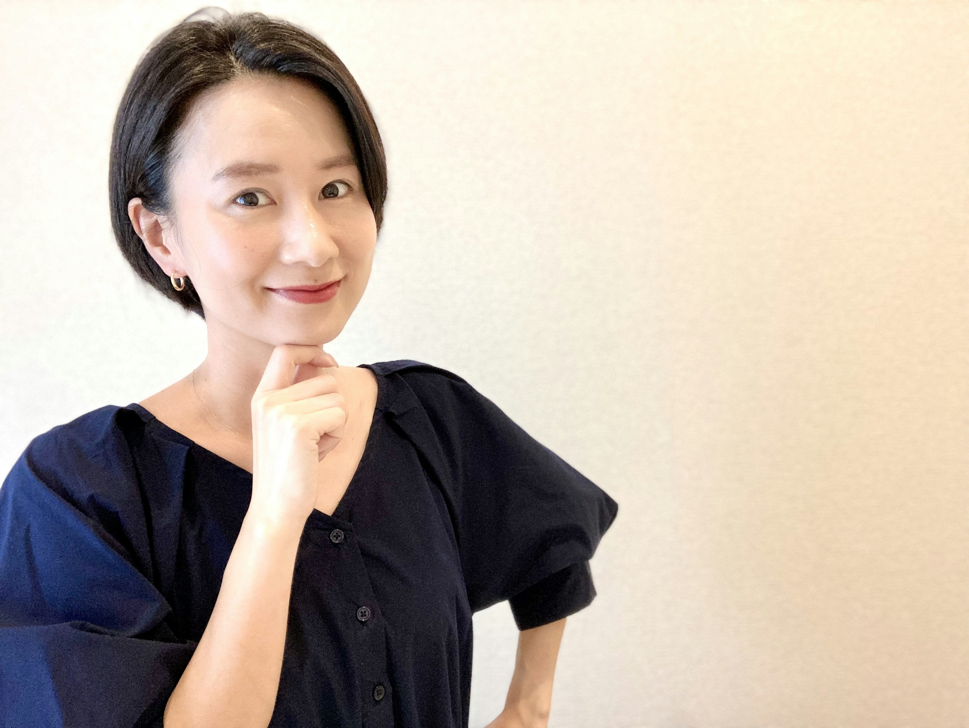 A woman with short hair posing thoughtfully