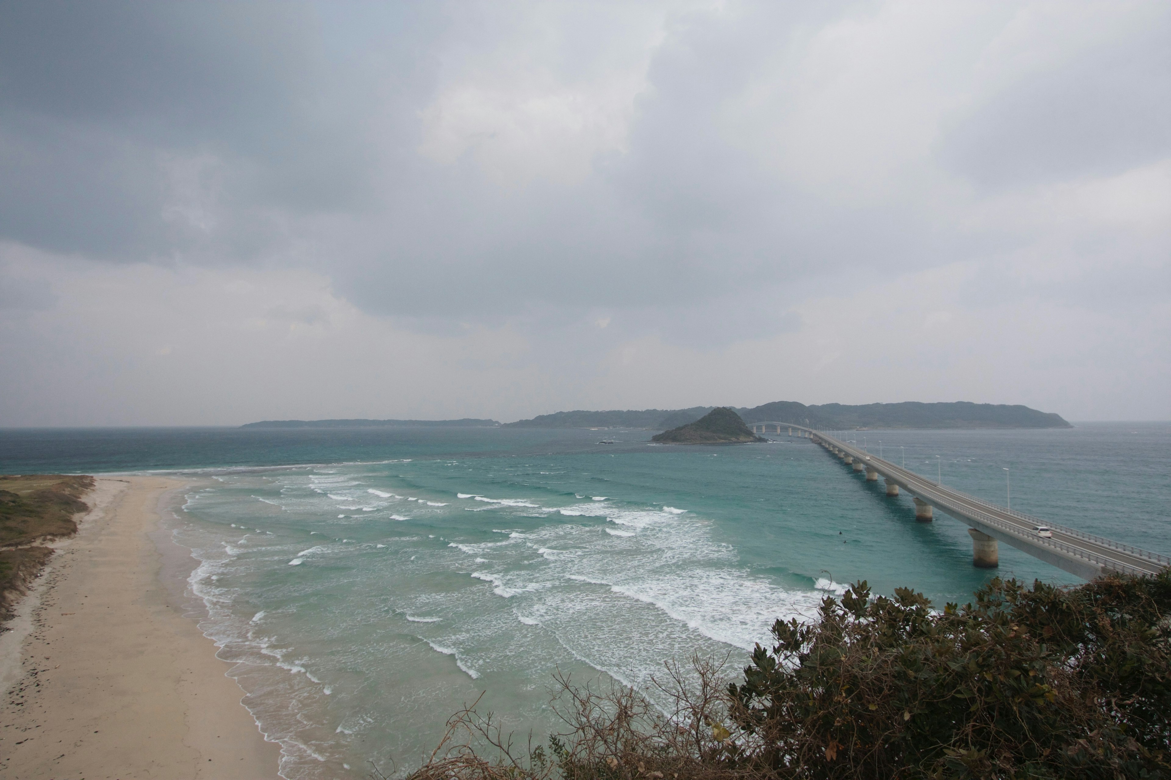 海岸风景，波浪和阴天，远处可见码头