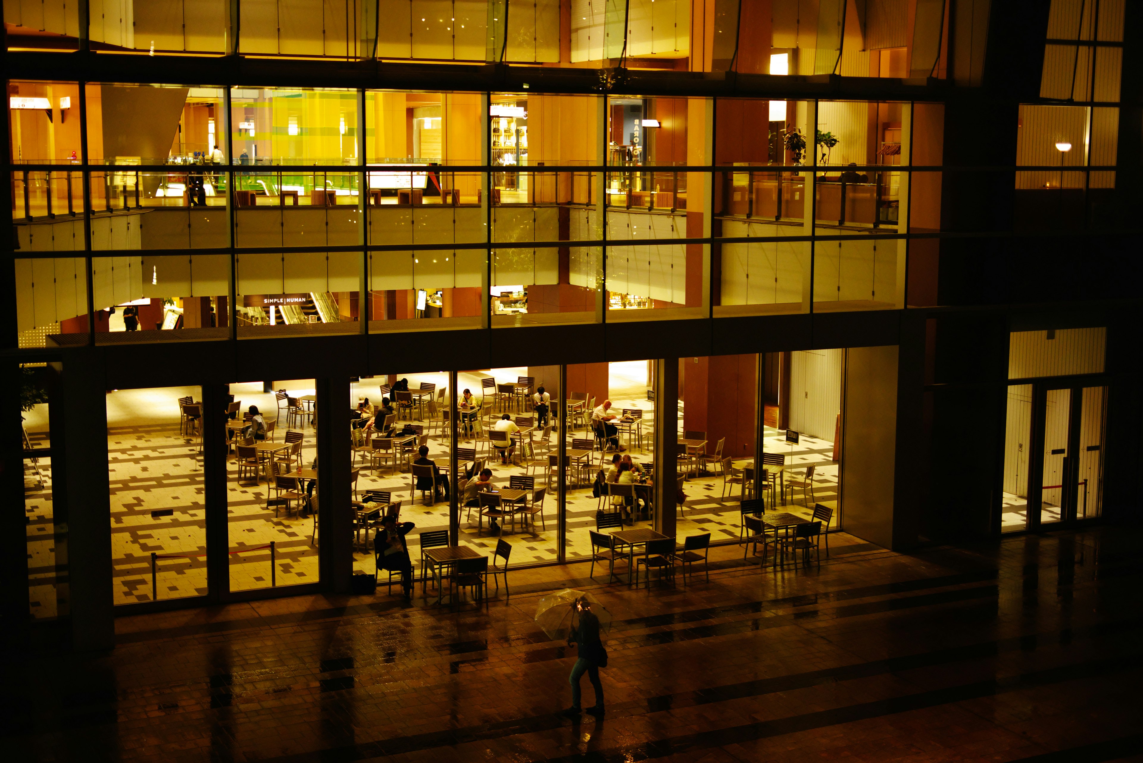 Bright dining area inside a building at night with tables