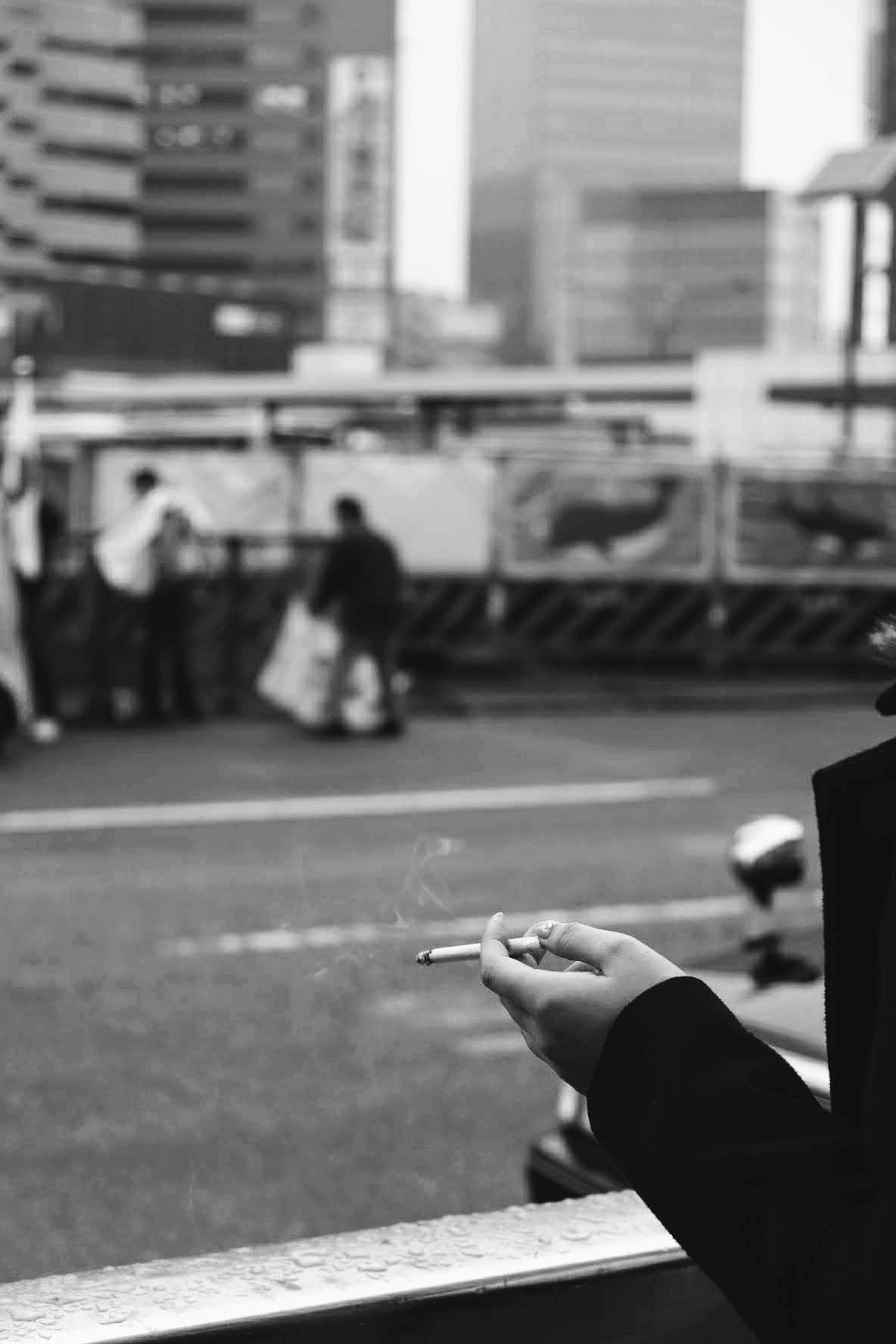 Person holding a cigarette with urban background