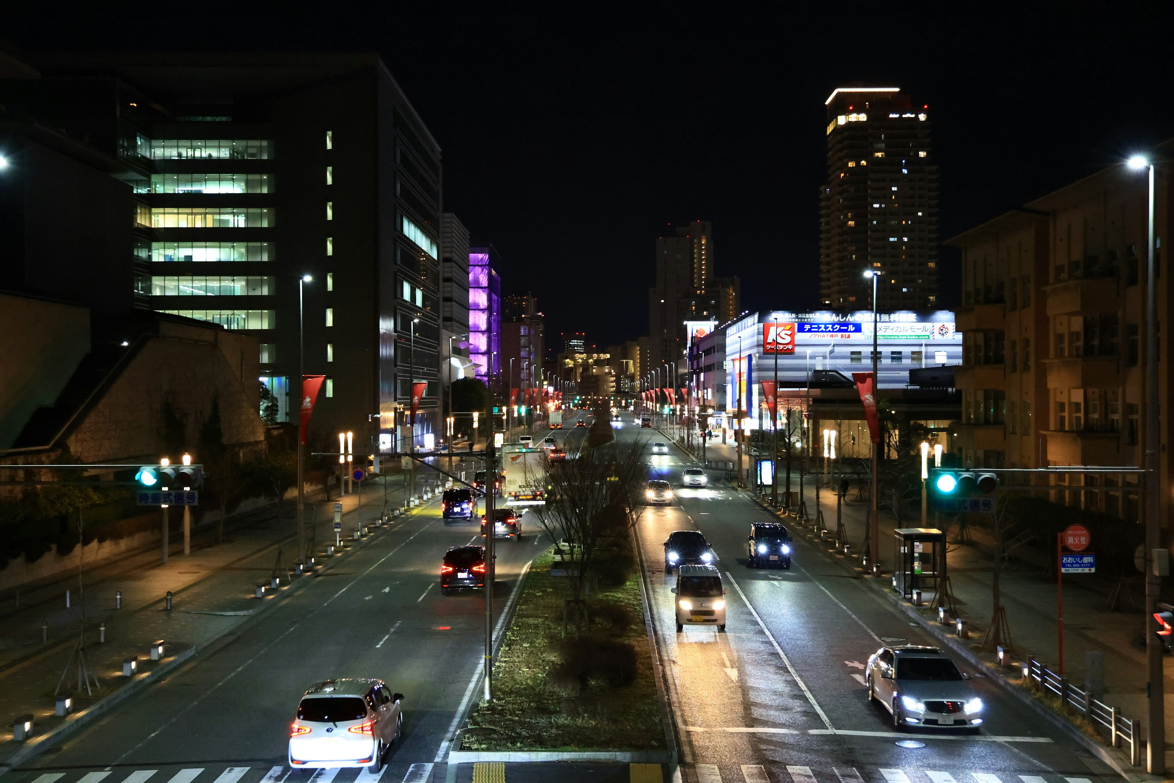 City street at night with cars and illuminated buildings