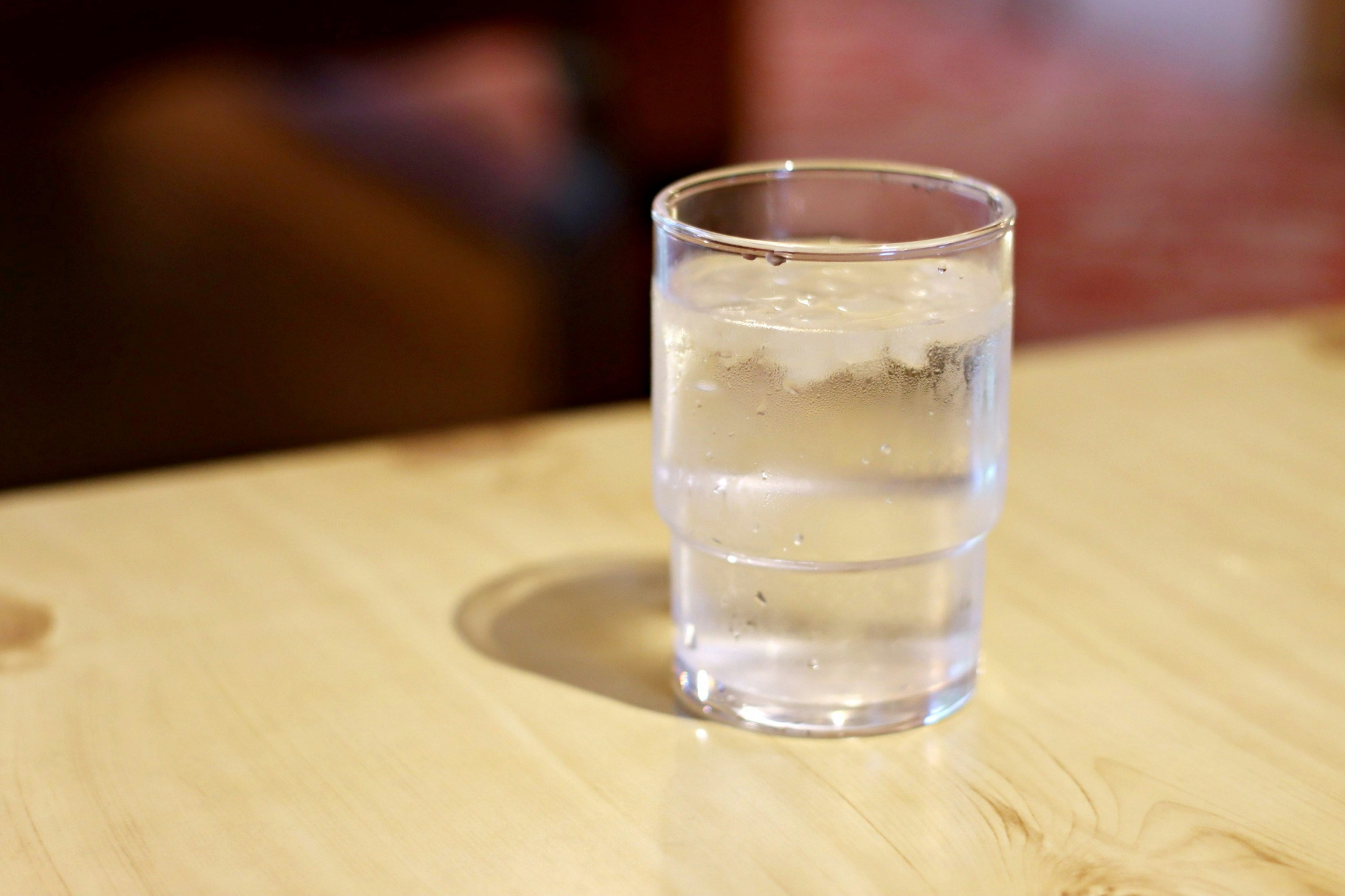 A glass of clear water on a wooden table