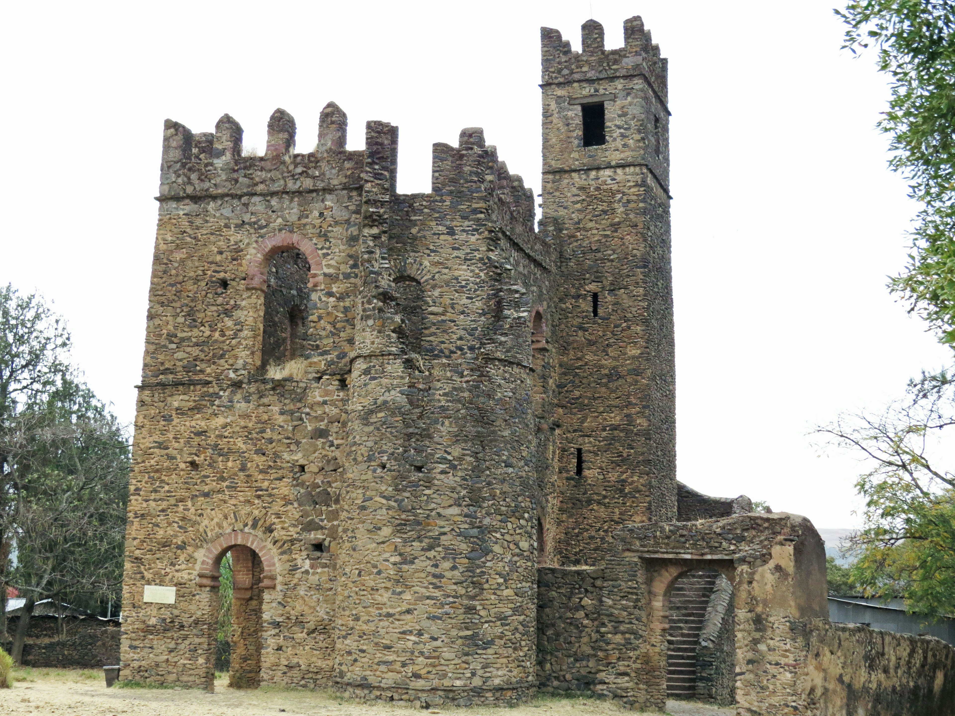 Rovine di un vecchio castello in pietra circondato da alberi verdi