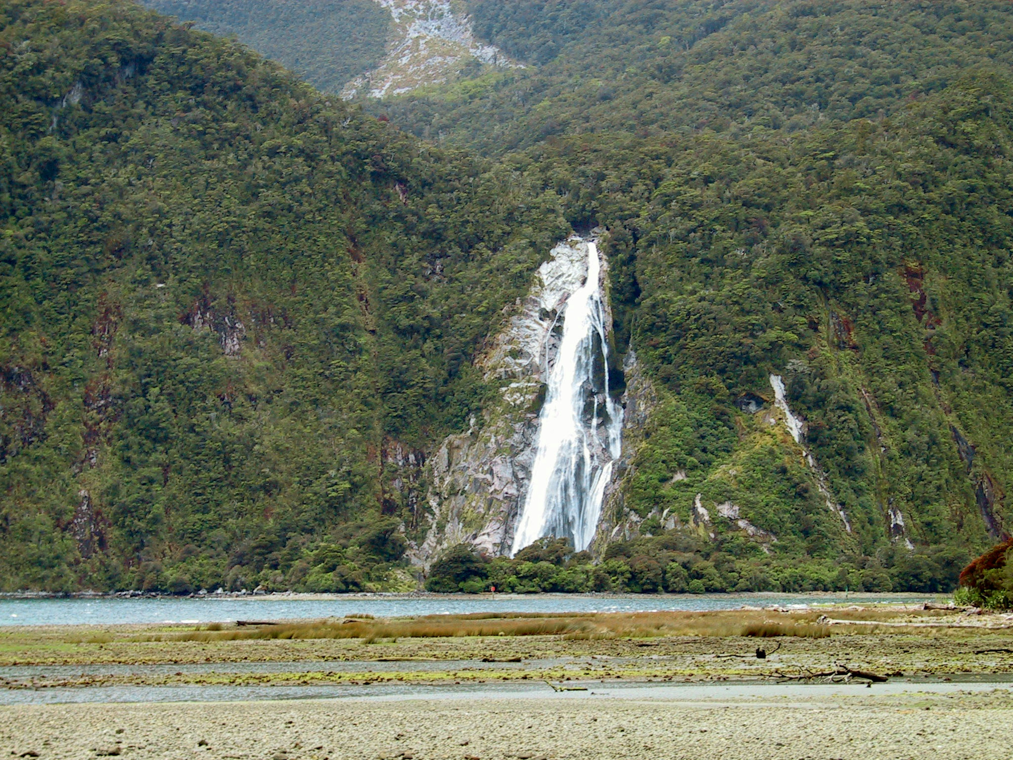 A beautiful waterfall cascading down surrounded by lush green mountains