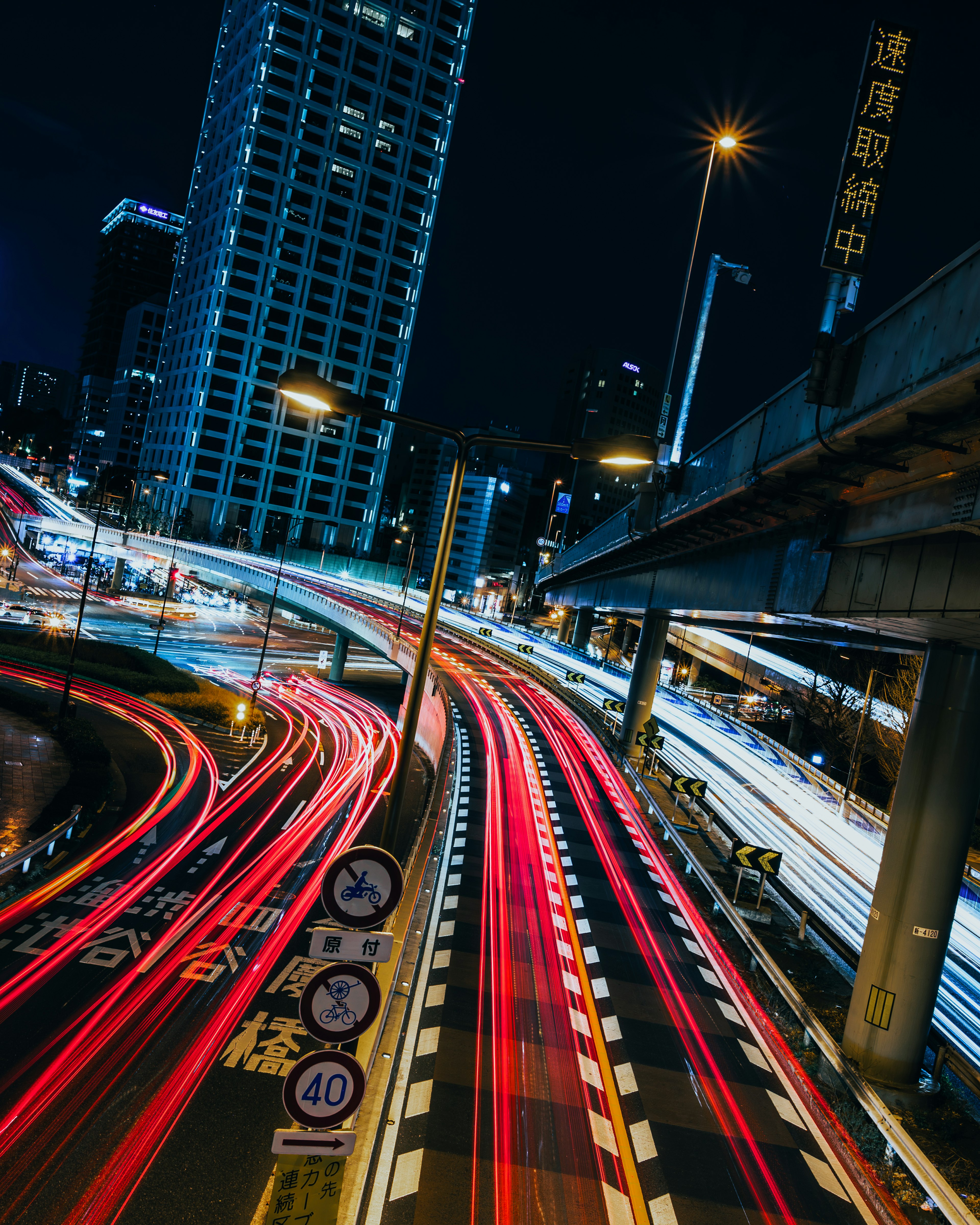 Trafic urbain nocturne avec des traînées lumineuses vives