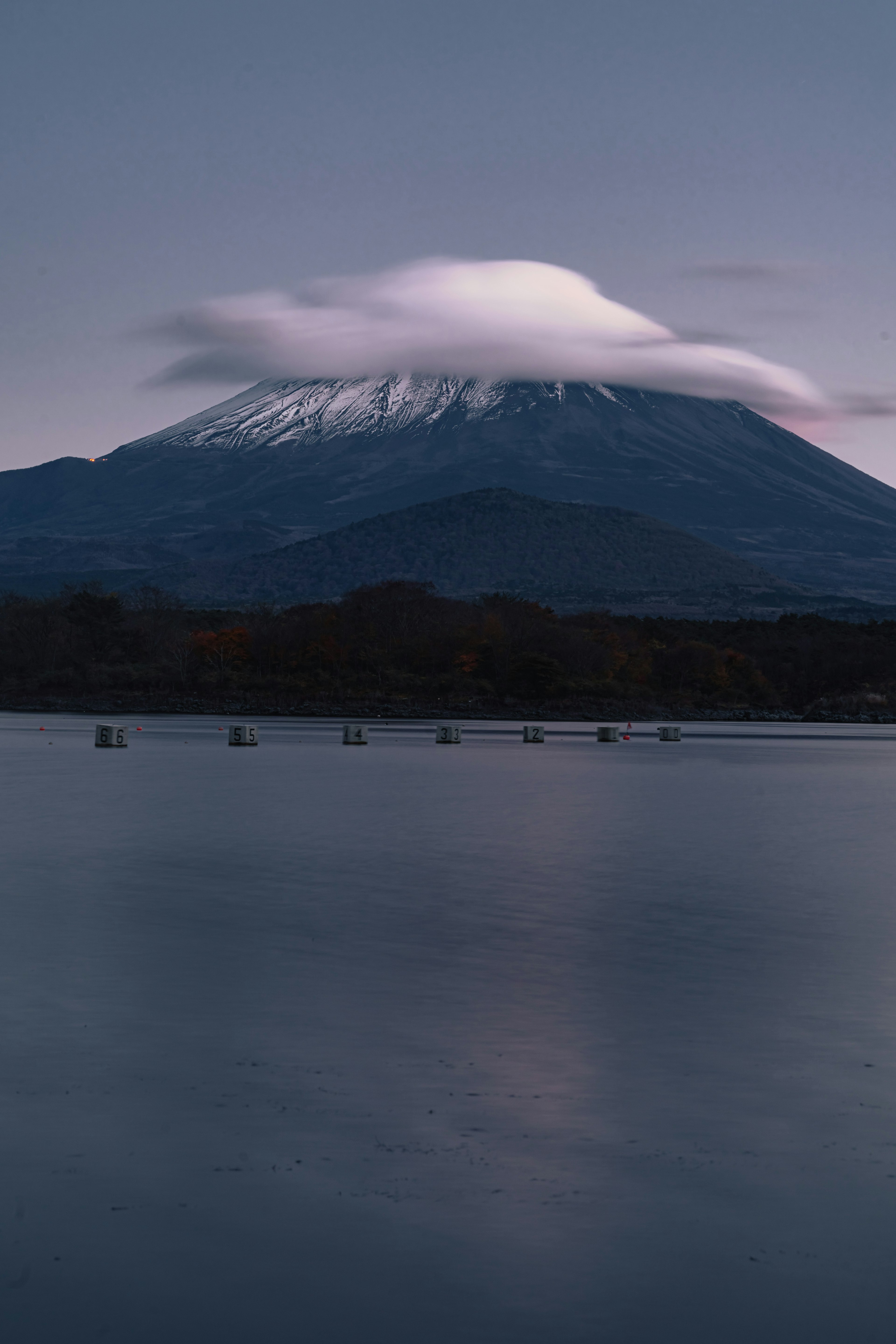 静かな湖の向こうにそびえる雪をかぶった山の美しい風景