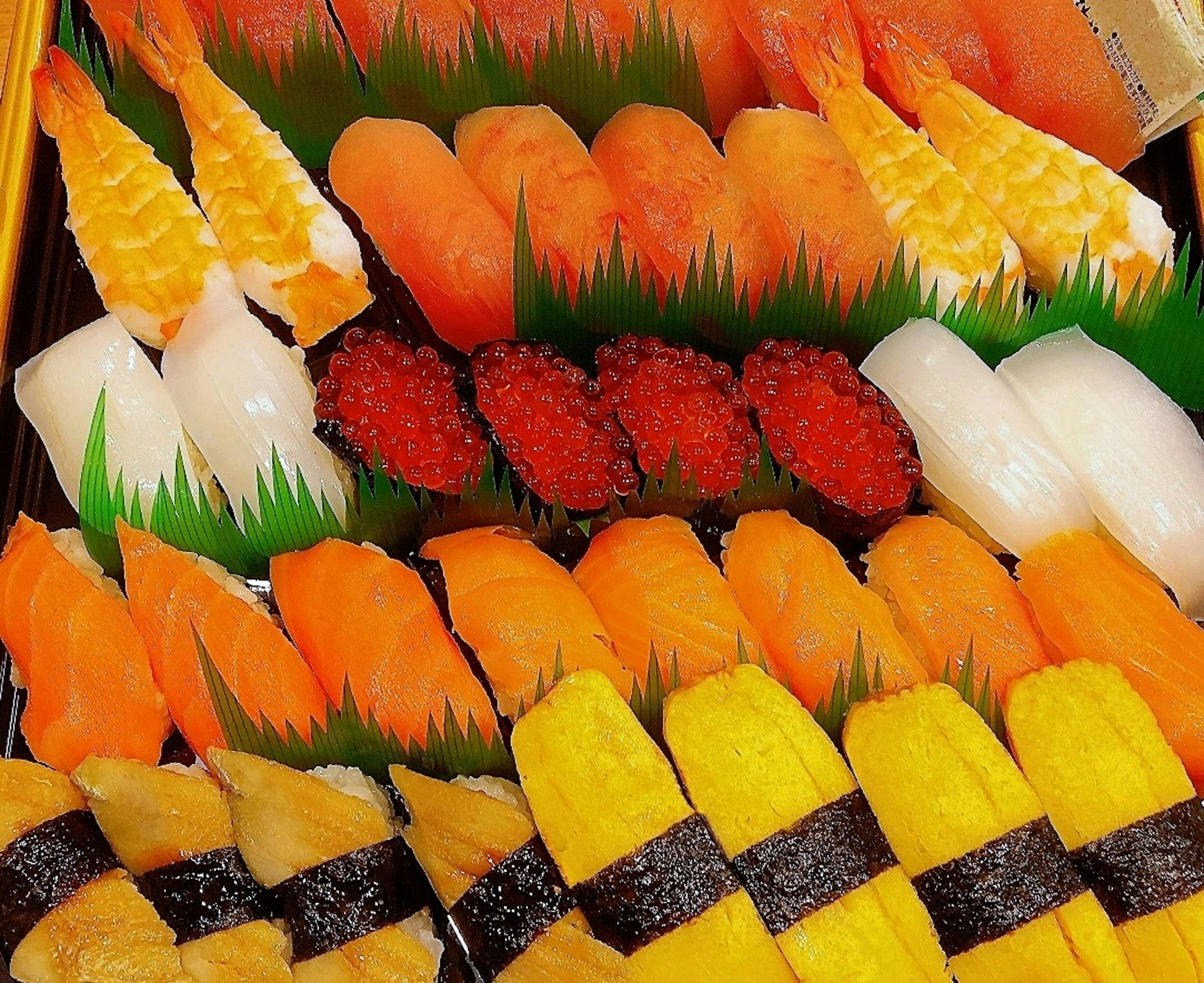 Colorful assortment of sushi featuring salmon and sea urchin