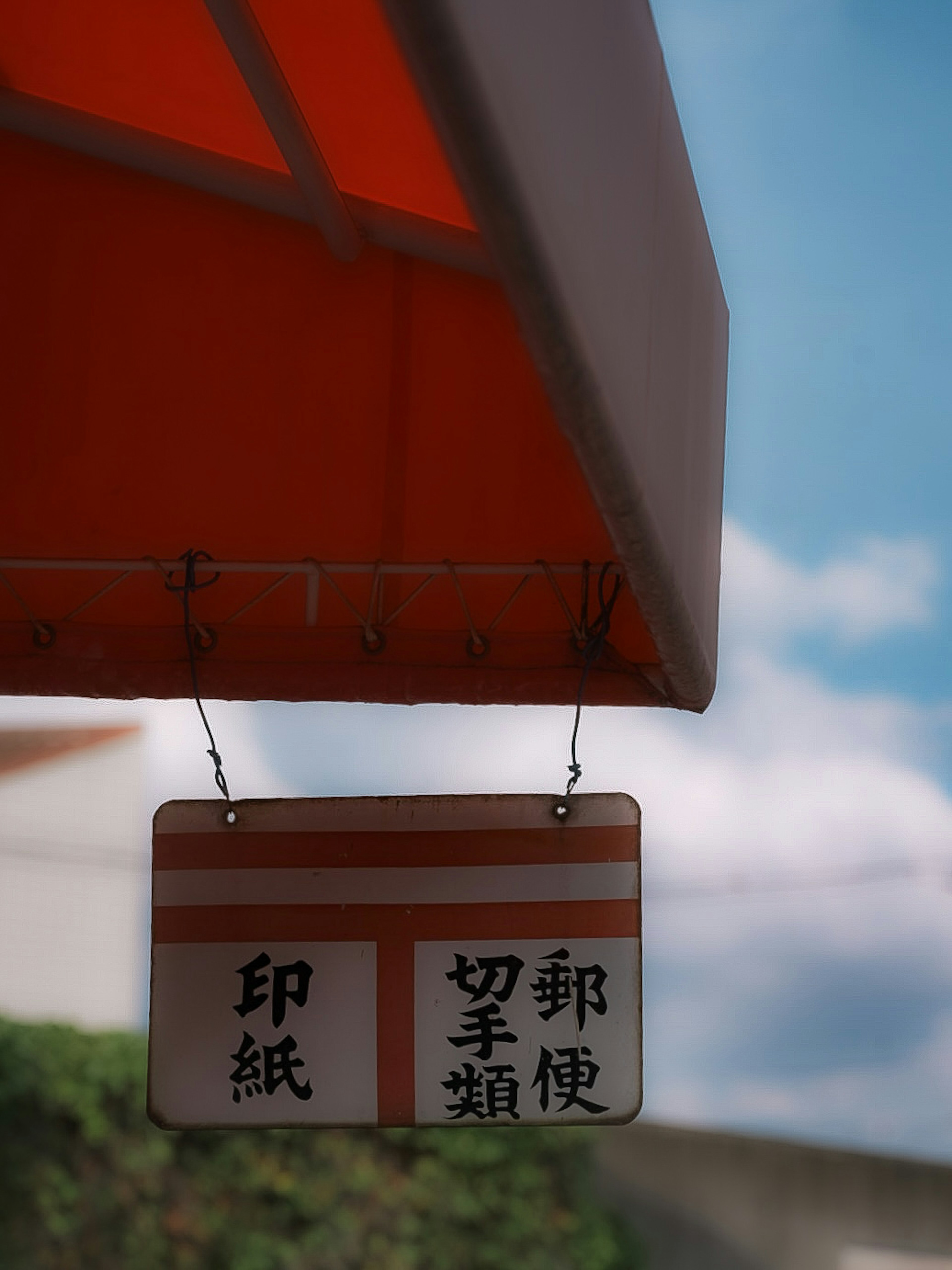 Ein Schild hängt unter einem orangefarbenen Vordach mit chinesischen Zeichen