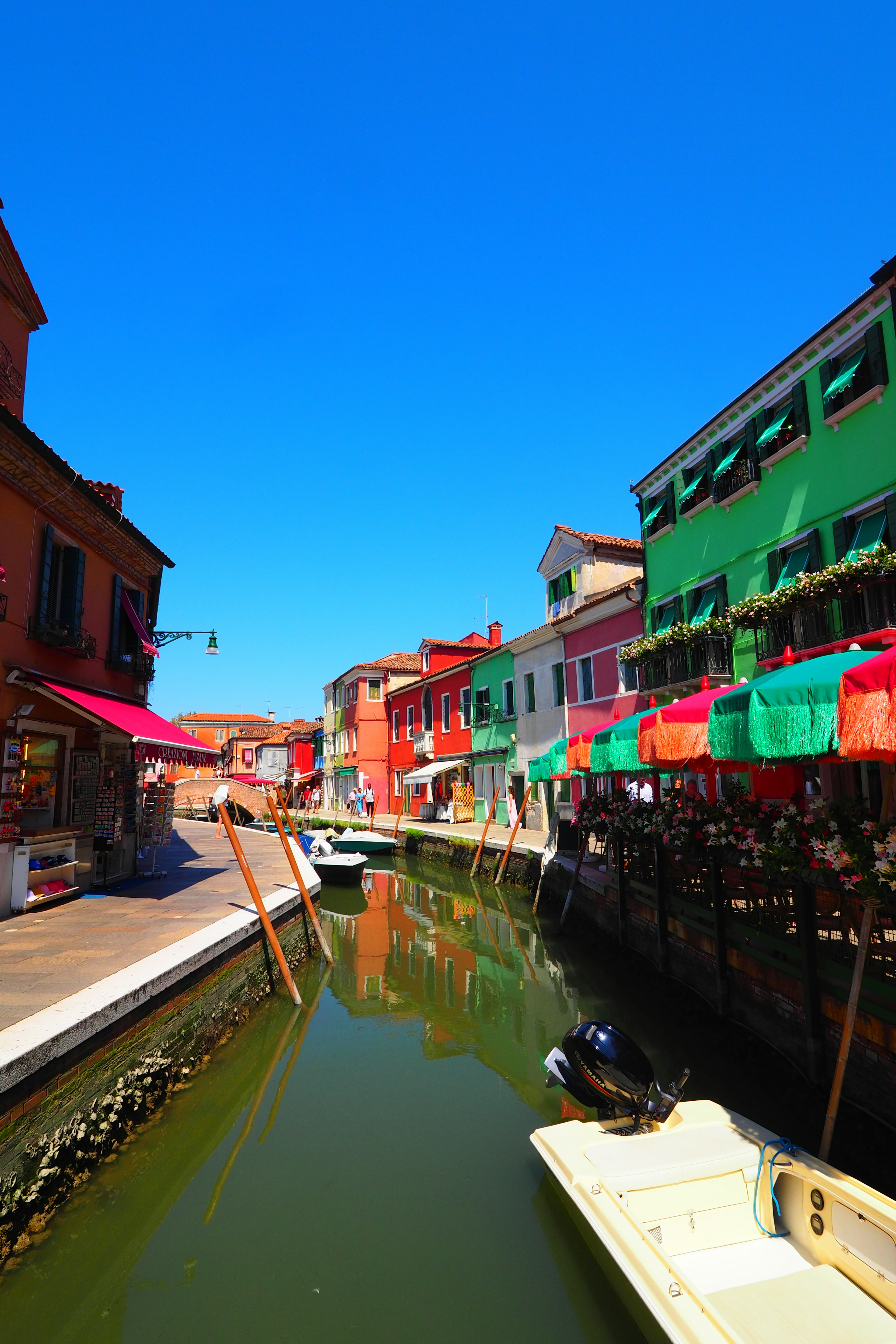 Des bâtiments colorés bordent un canal sous un ciel bleu clair