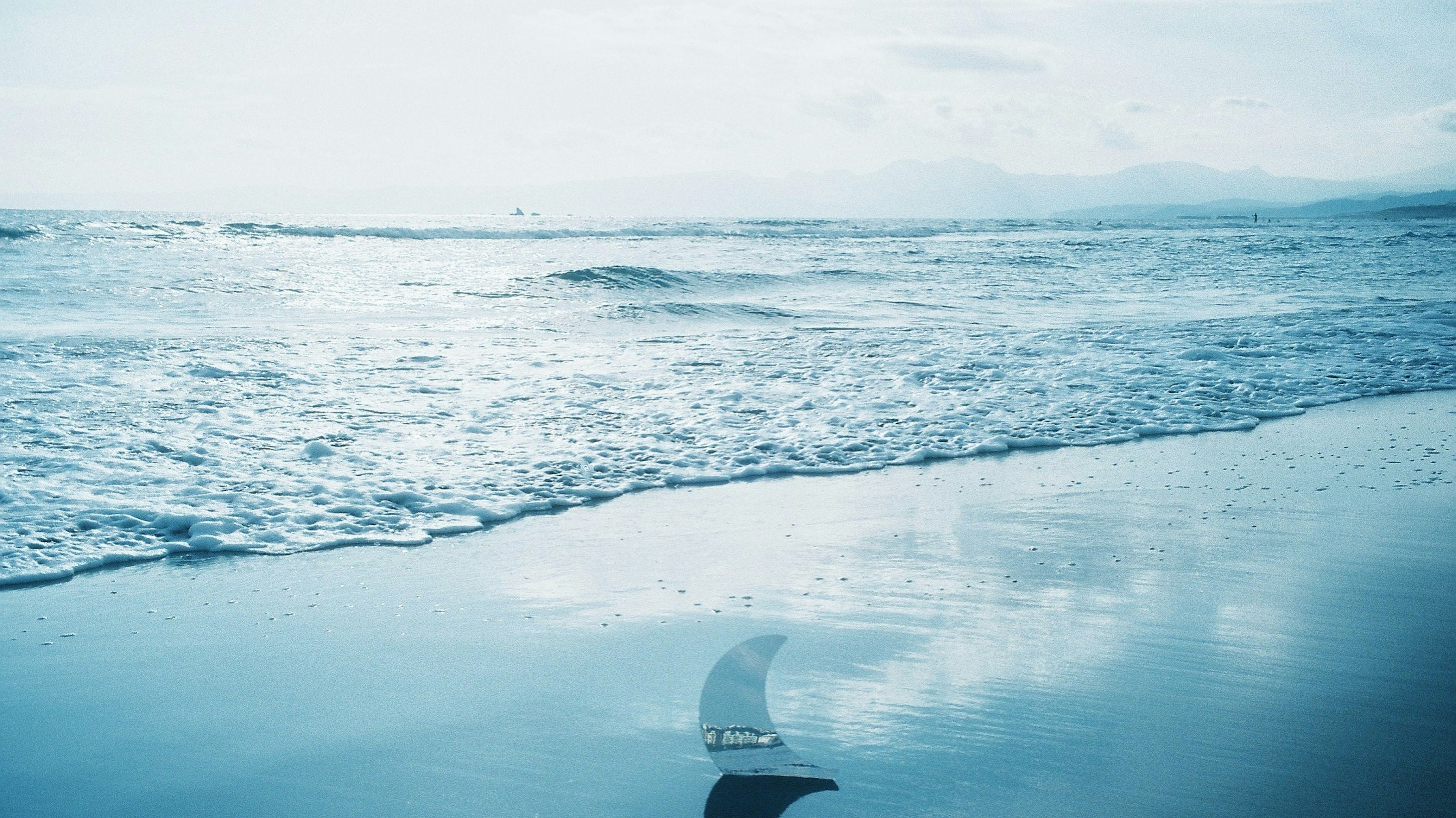 穏やかな海の風景と青い空が広がるビーチの画像