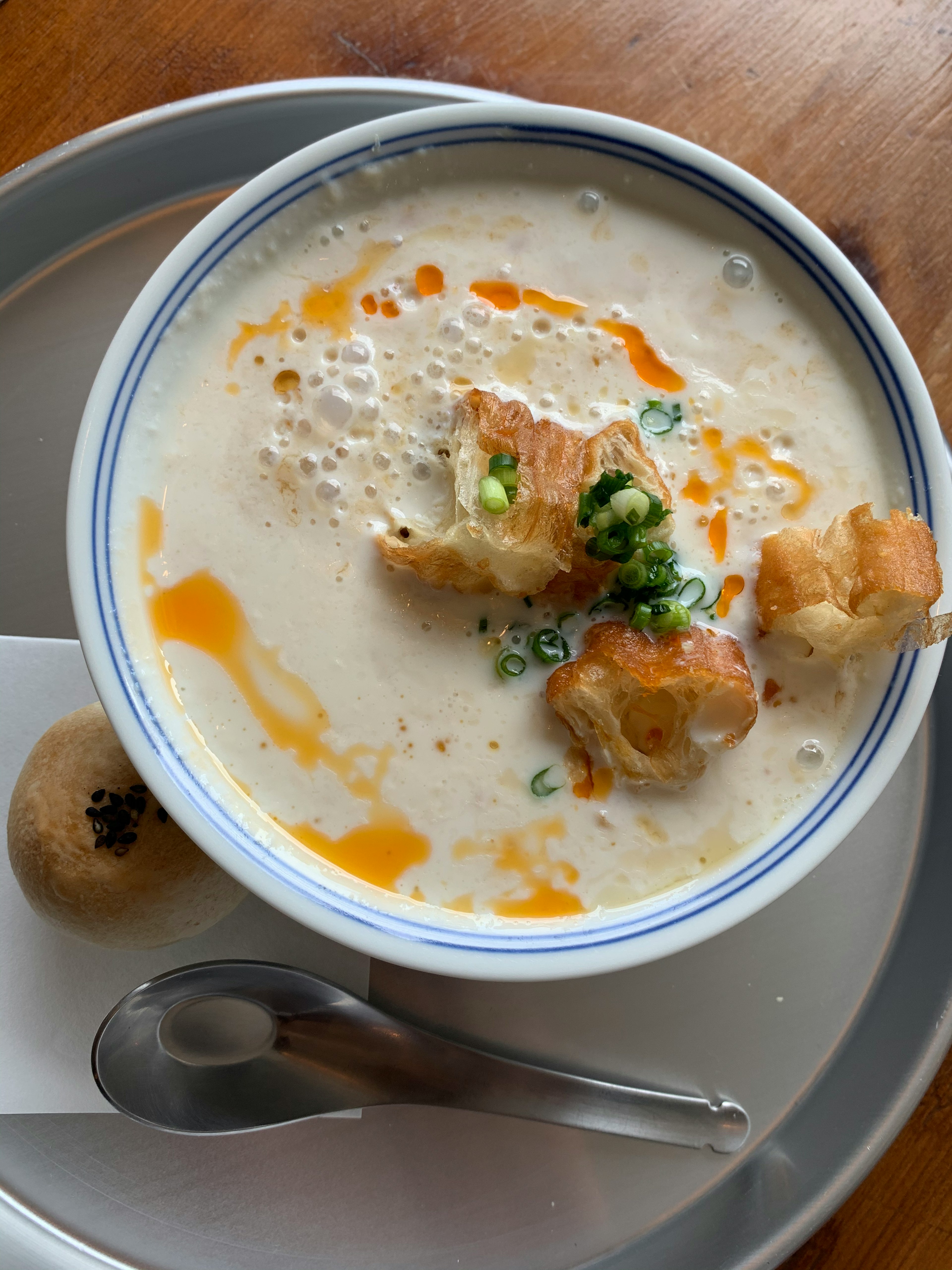 Zuppa cremosa guarnita con pane croccante e cipolle verdi in una ciotola