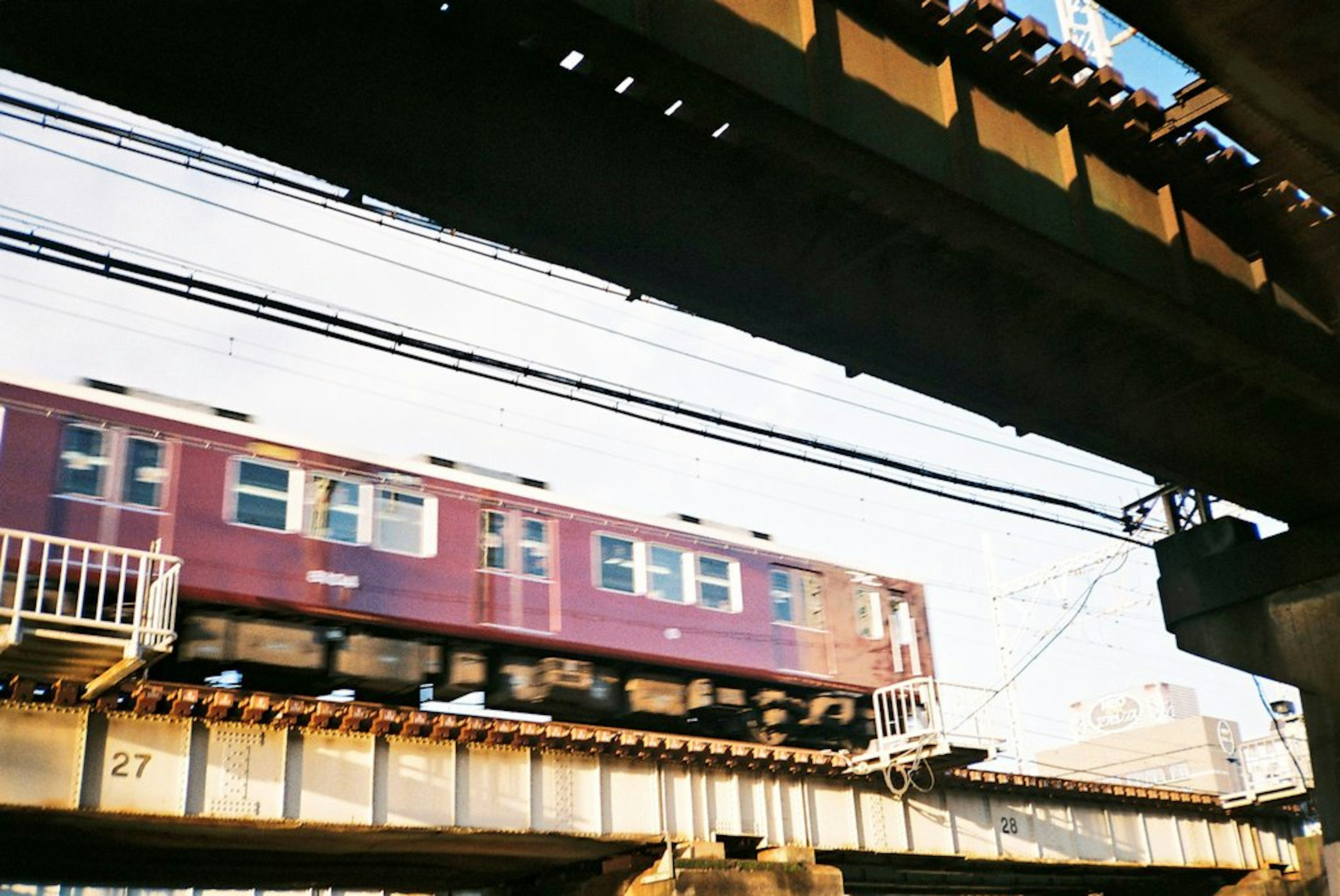 Treno rosso che passa sopra un ponte in un contesto urbano