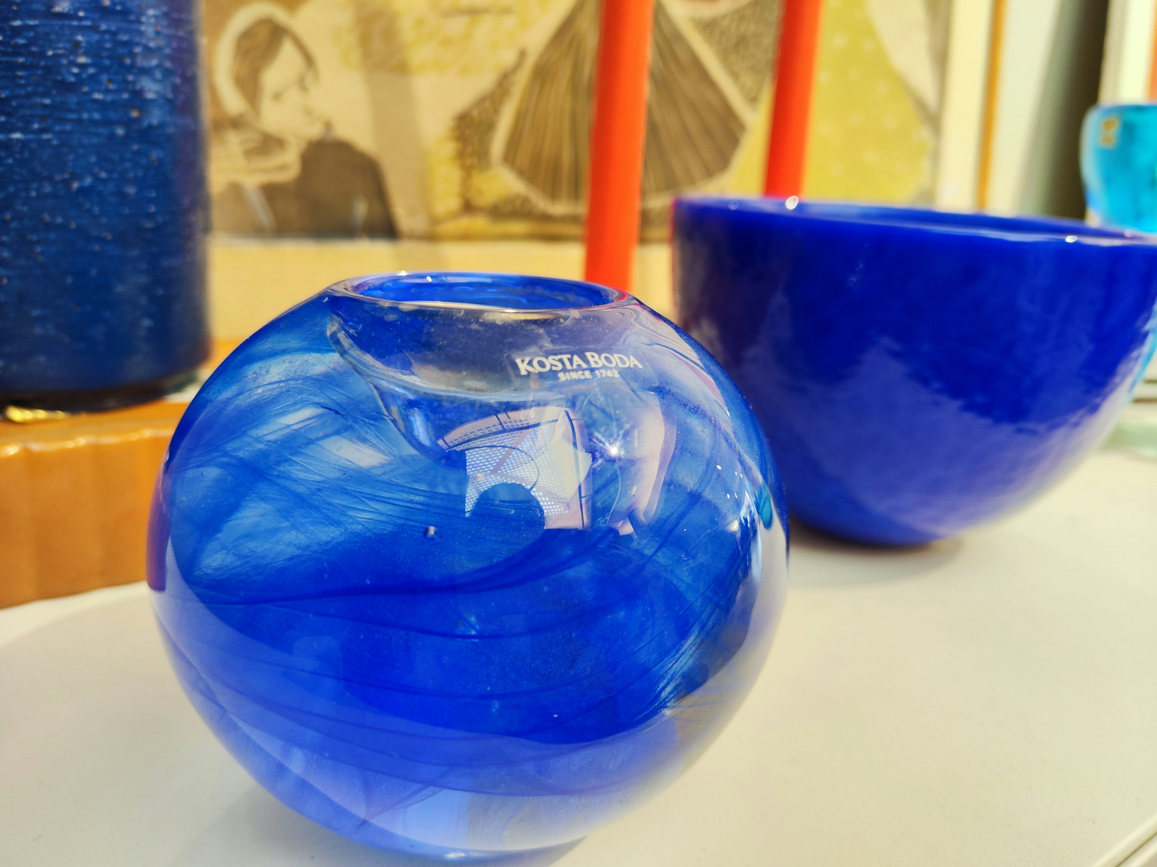 Eine blaue Glas-Kugel und eine Schüssel zusammen ausgestellt