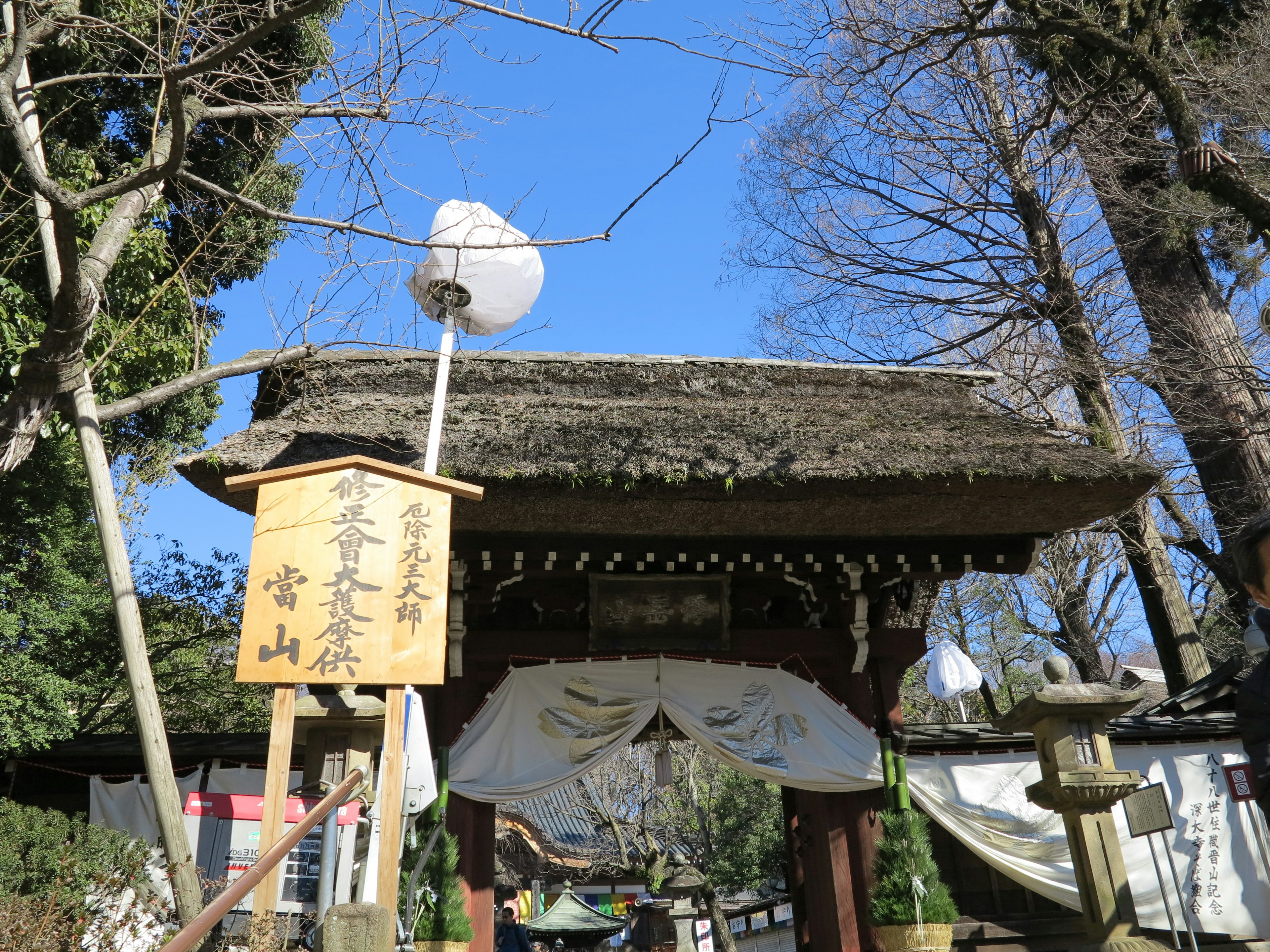 Pintu tradisional Jepang dengan tanda tulisan tangan di lingkungan yang tenang