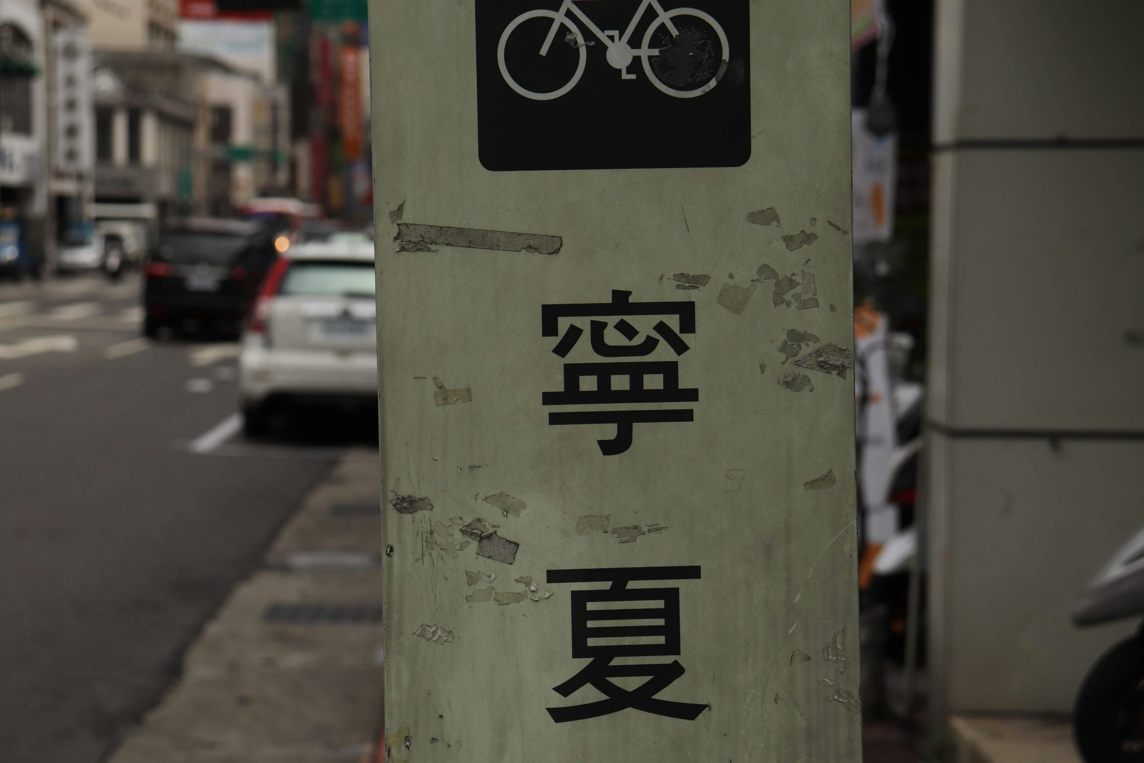 Straßenschild mit Fahrradsymbol und chinesischen Schriftzeichen