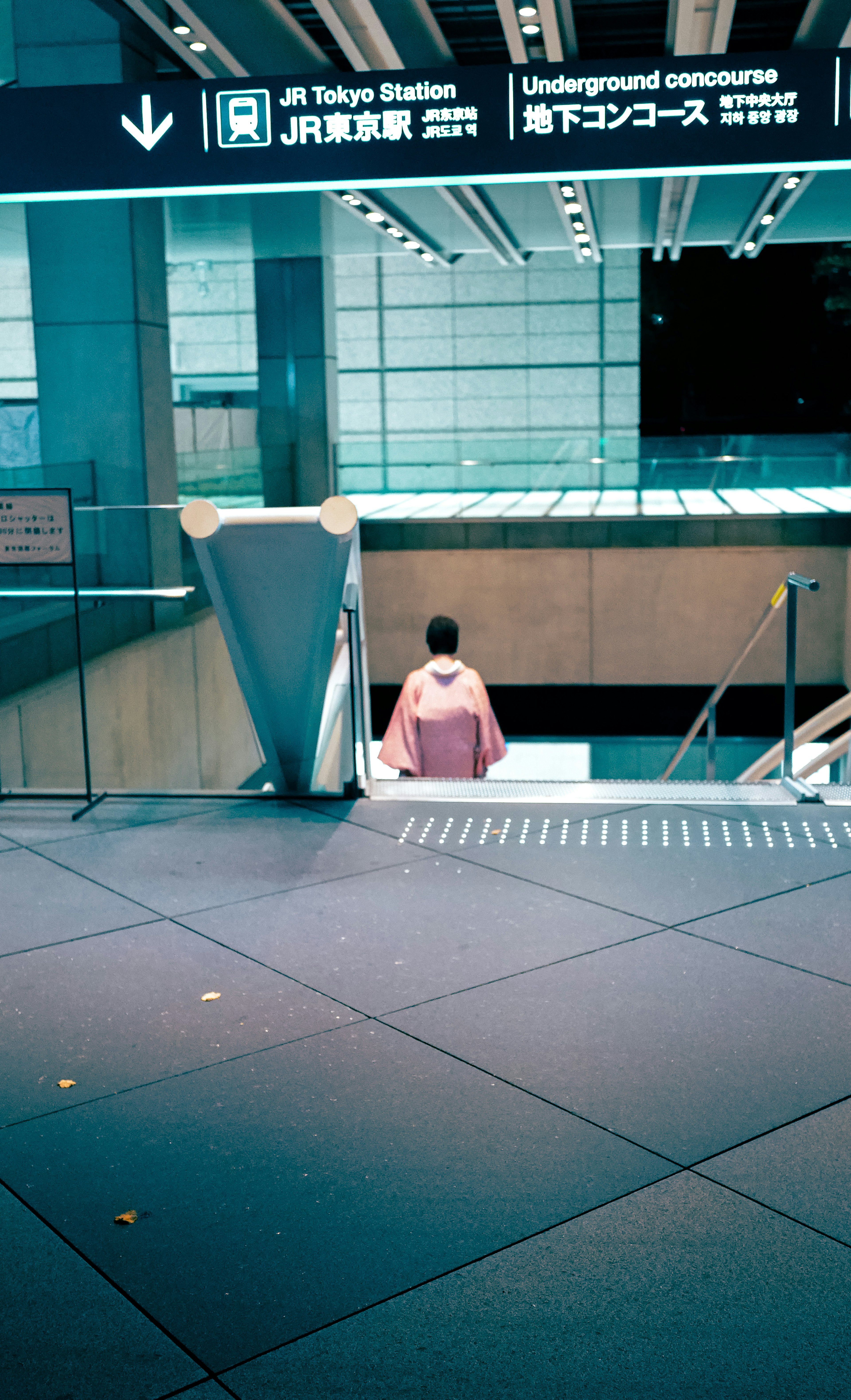 Orang duduk di dekat loket di Stasiun Tokyo dengan interior modern