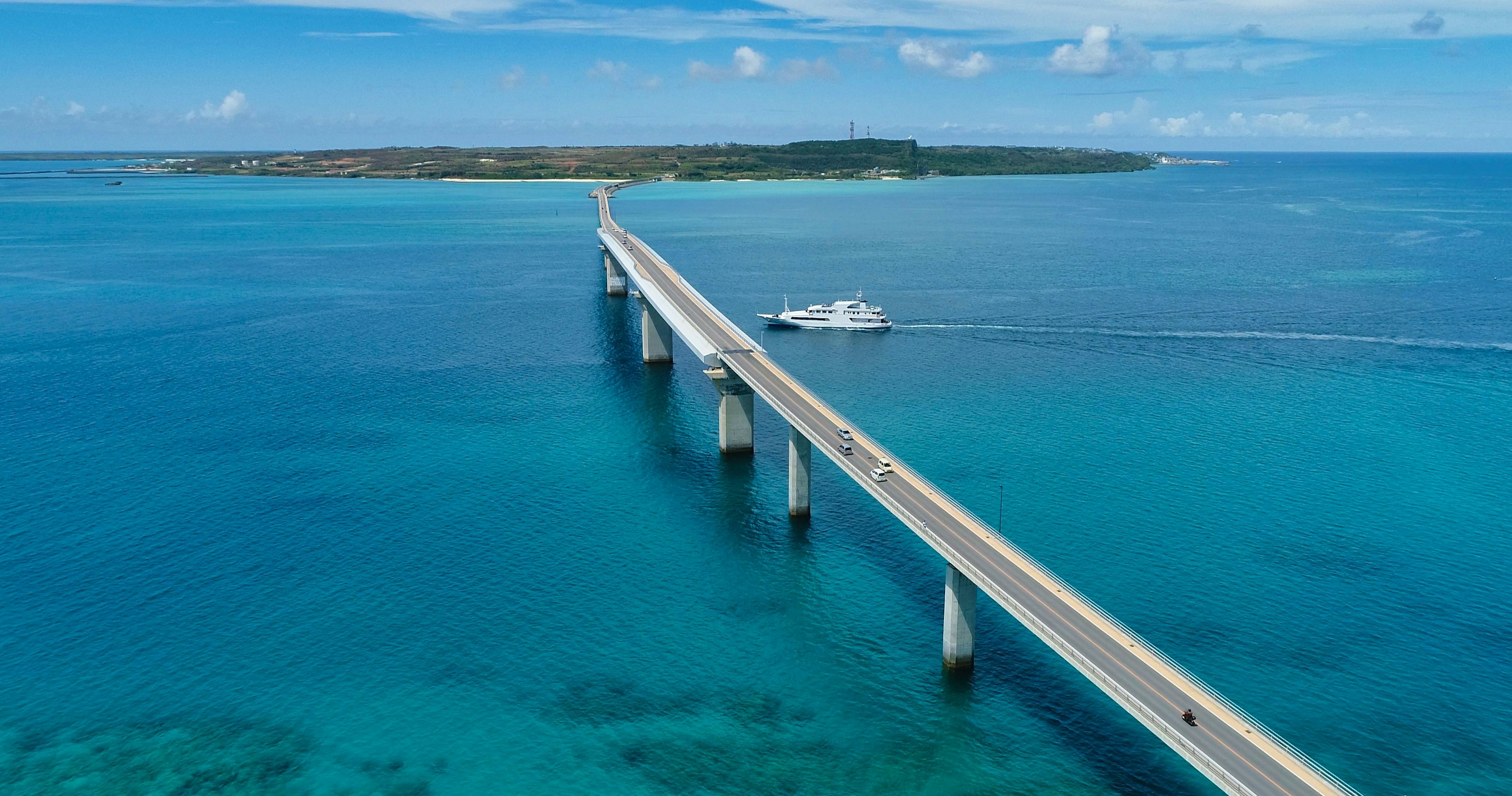 Langer Brücke über den blauen Ozean mit einem Boot