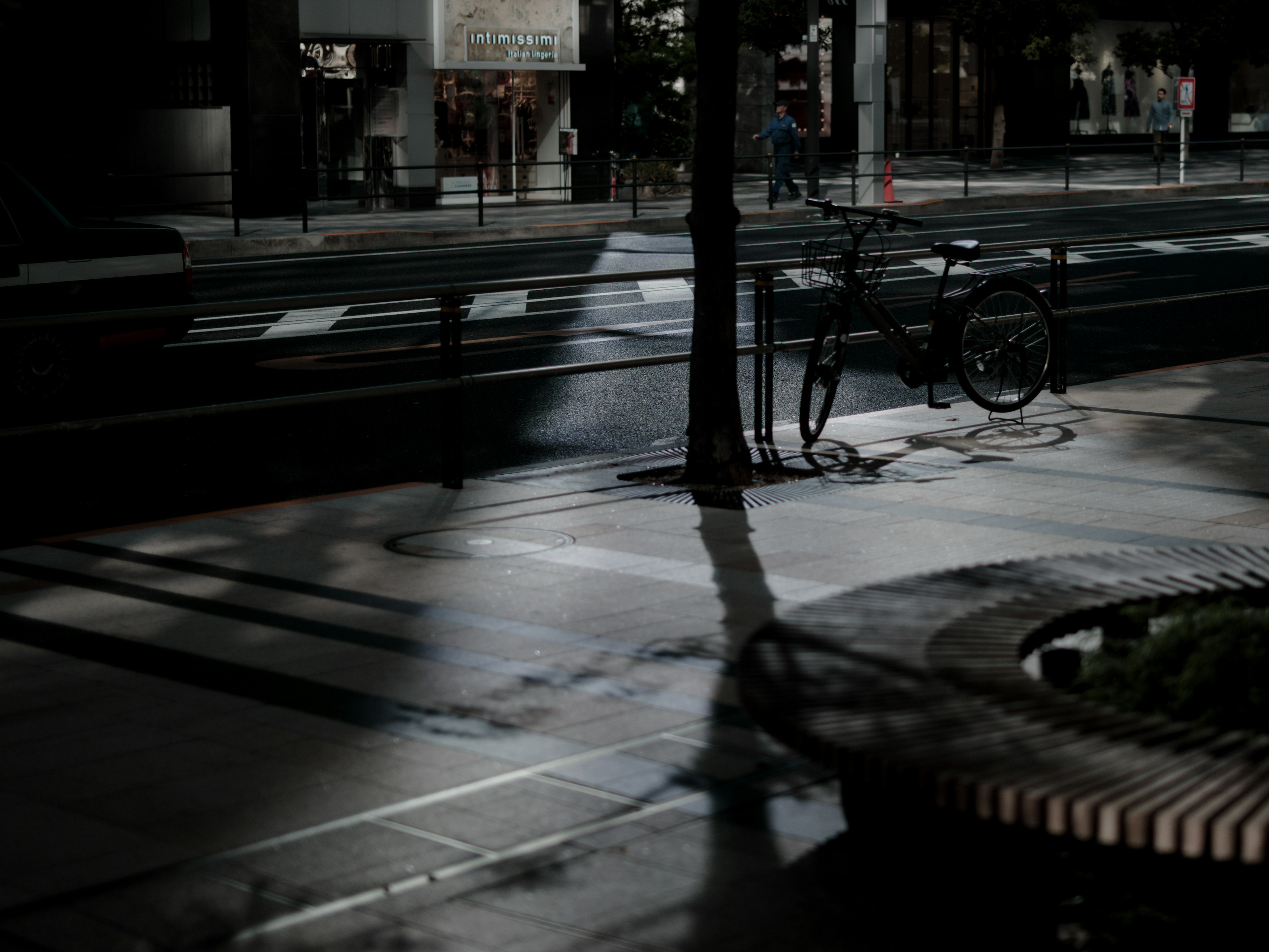 A dark street corner featuring a bicycle and reflections in puddles