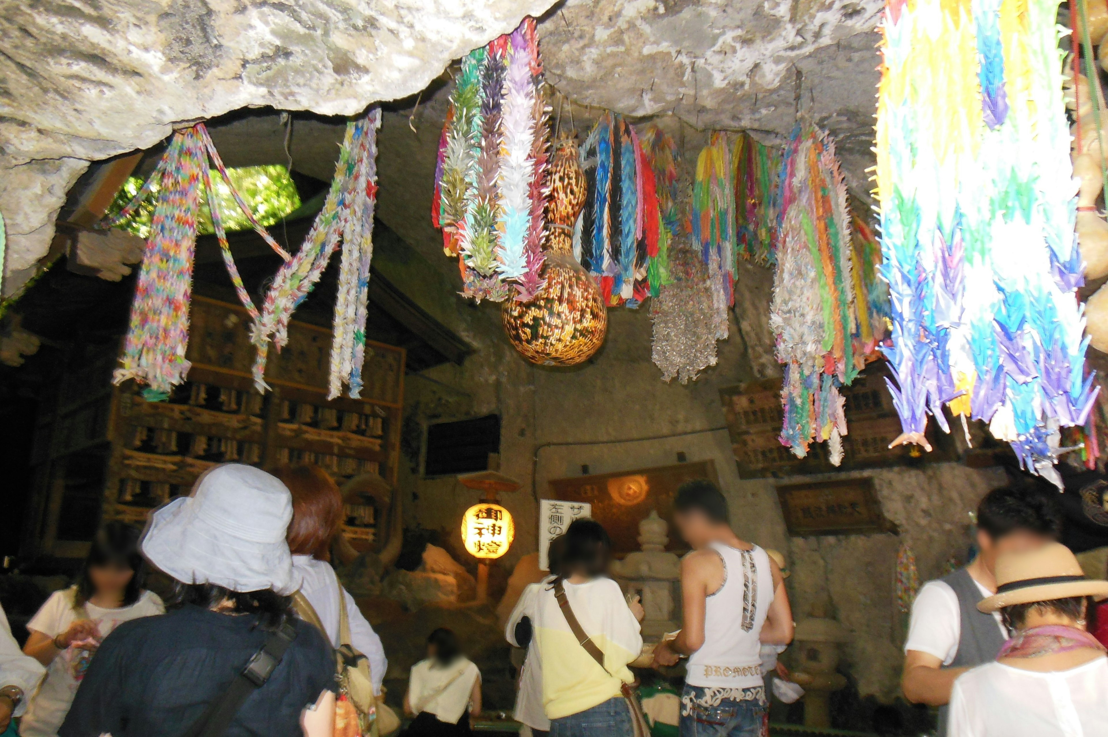 Interior of a cave with people gathered colorful decorations hanging from the ceiling