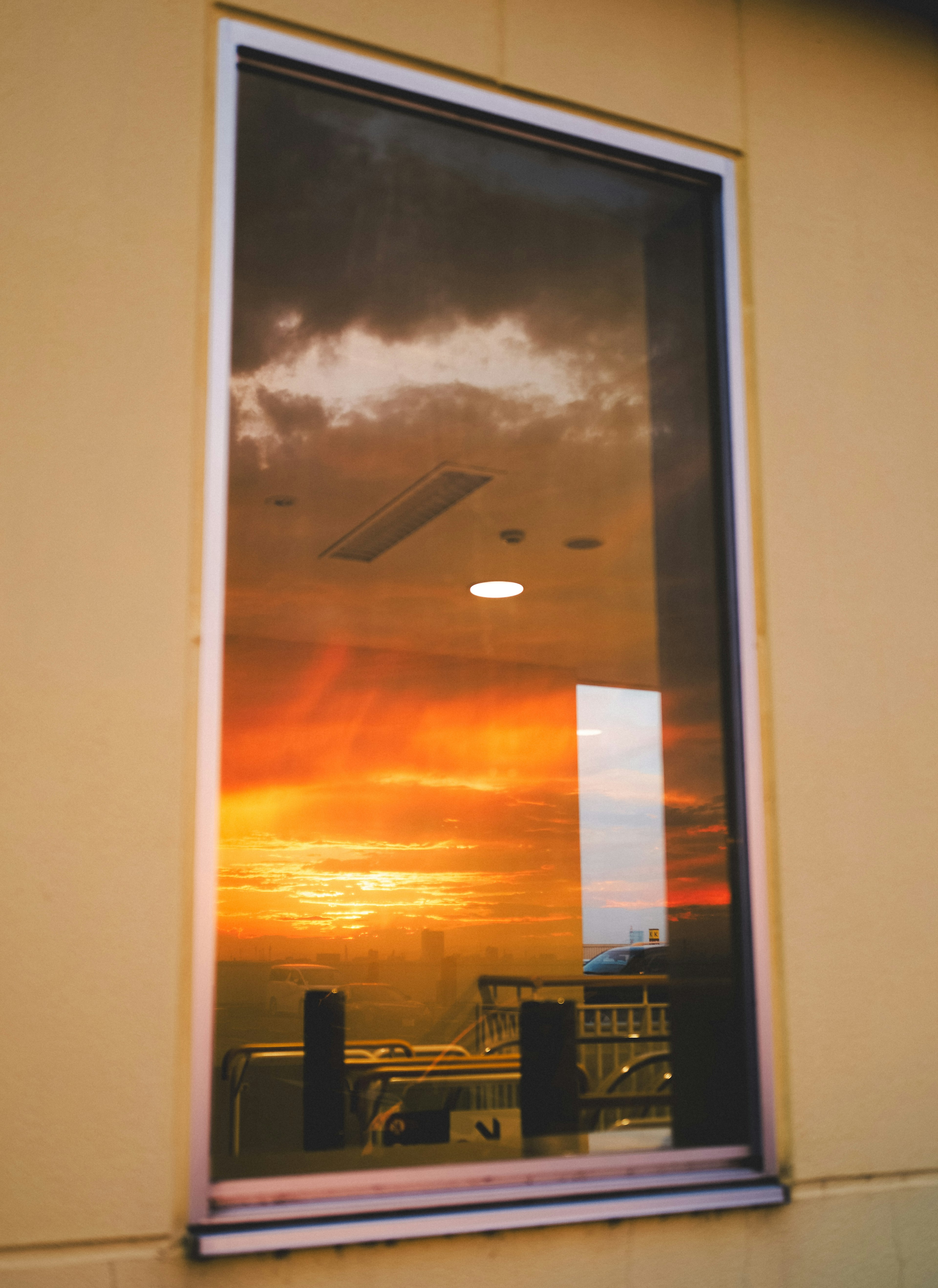 Reflexion eines Sonnenuntergangshimmels und Wolken in einem Fenster