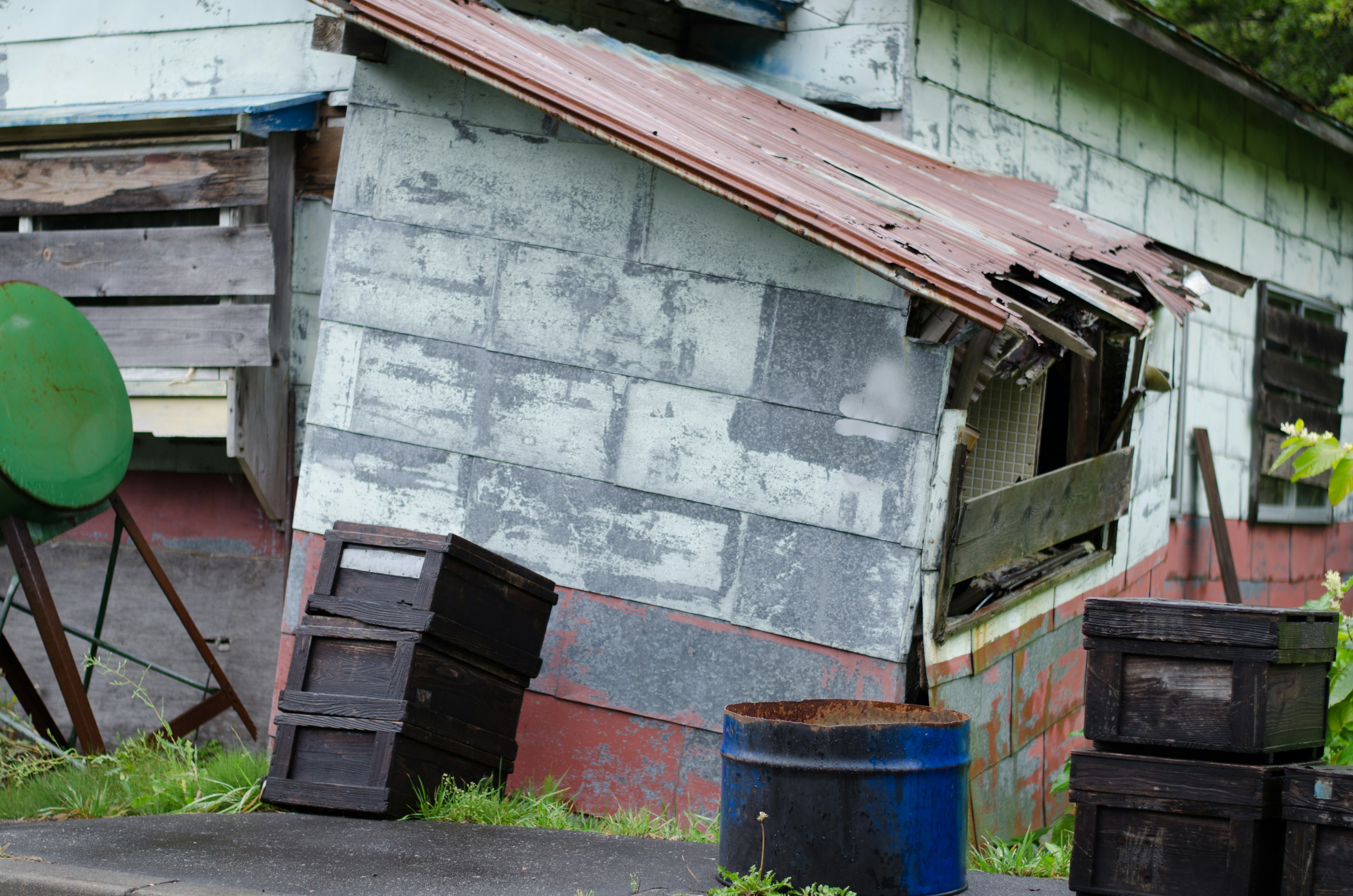 Tilted old house with surrounding debris