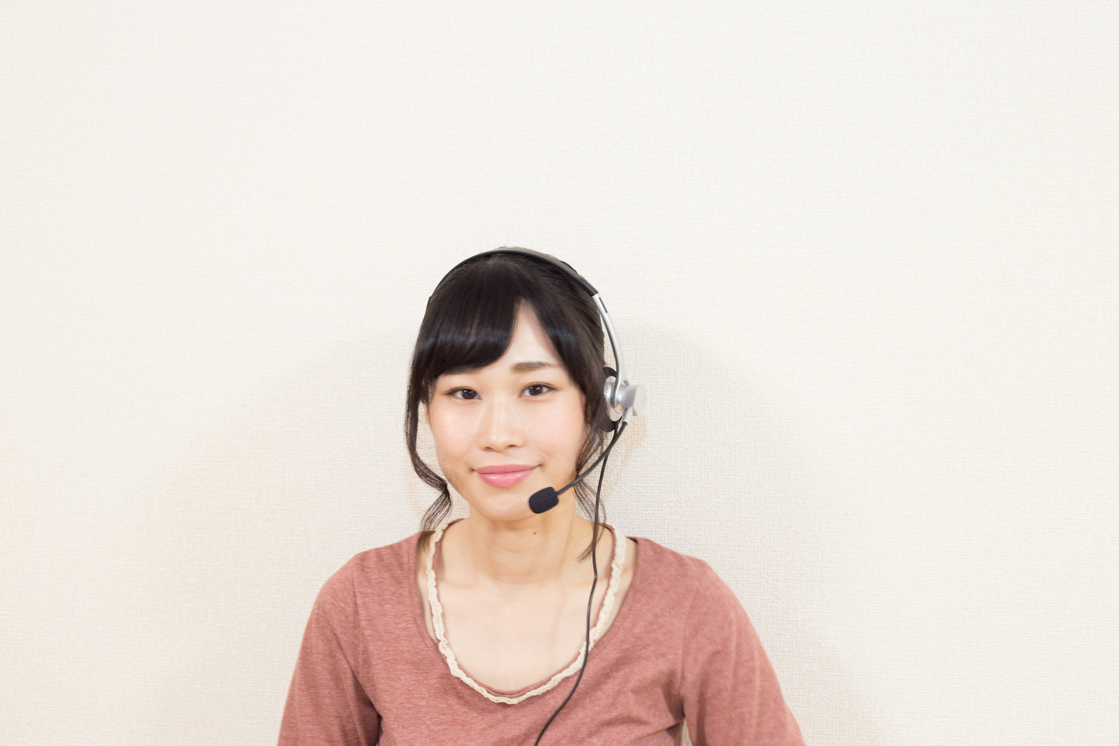 Portrait of a woman wearing a headset with a simple background