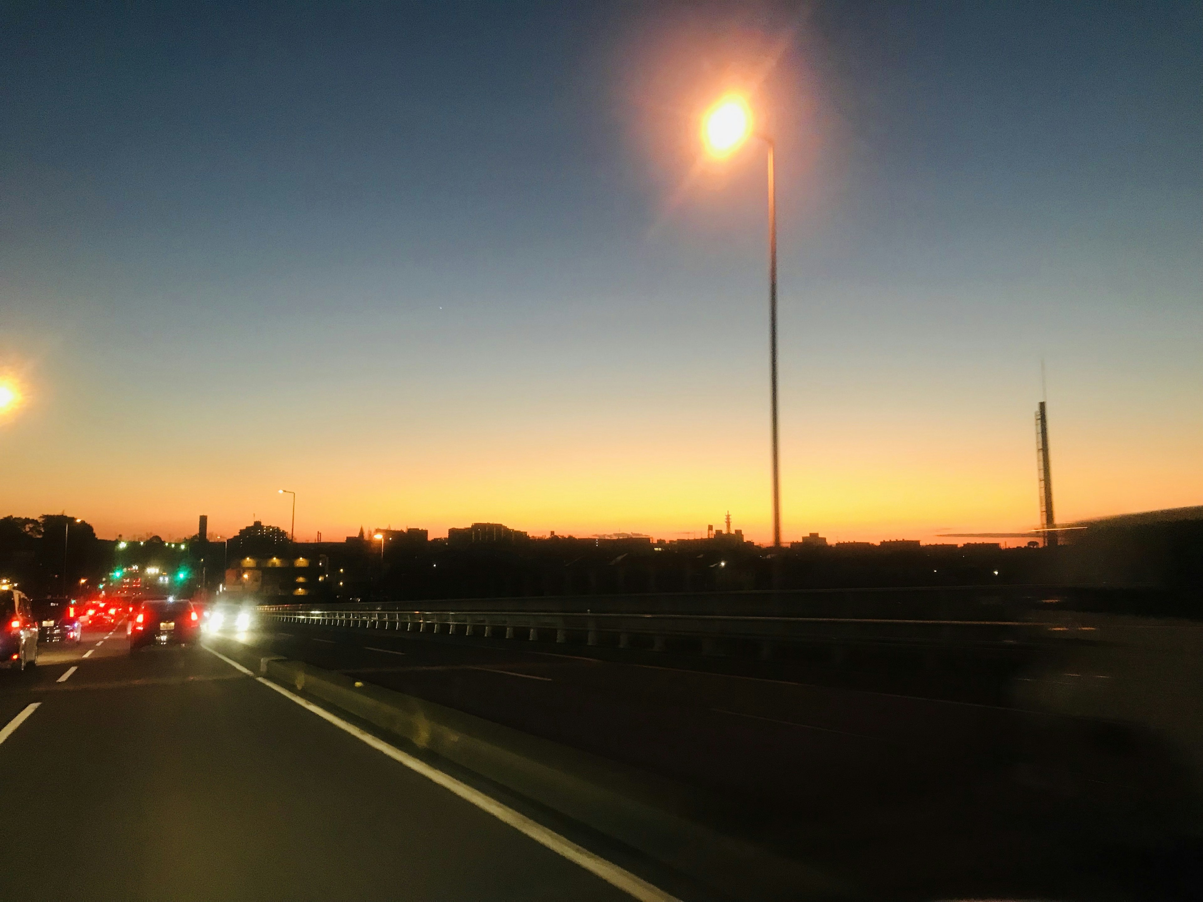 Paisaje urbano al atardecer con una carretera y farolas