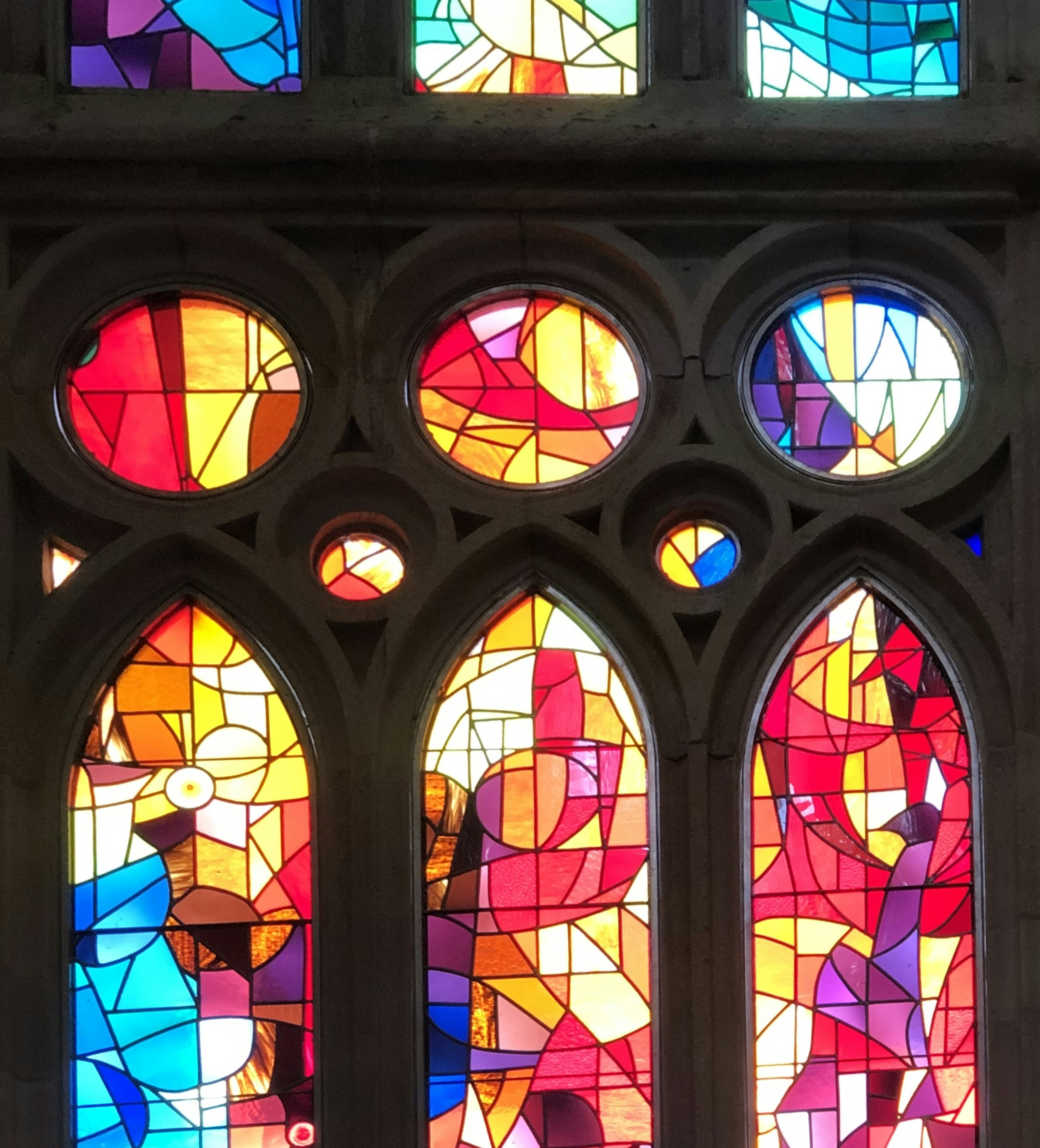 Buntes Buntglasfenster mit geometrischen Mustern in einer Kirche