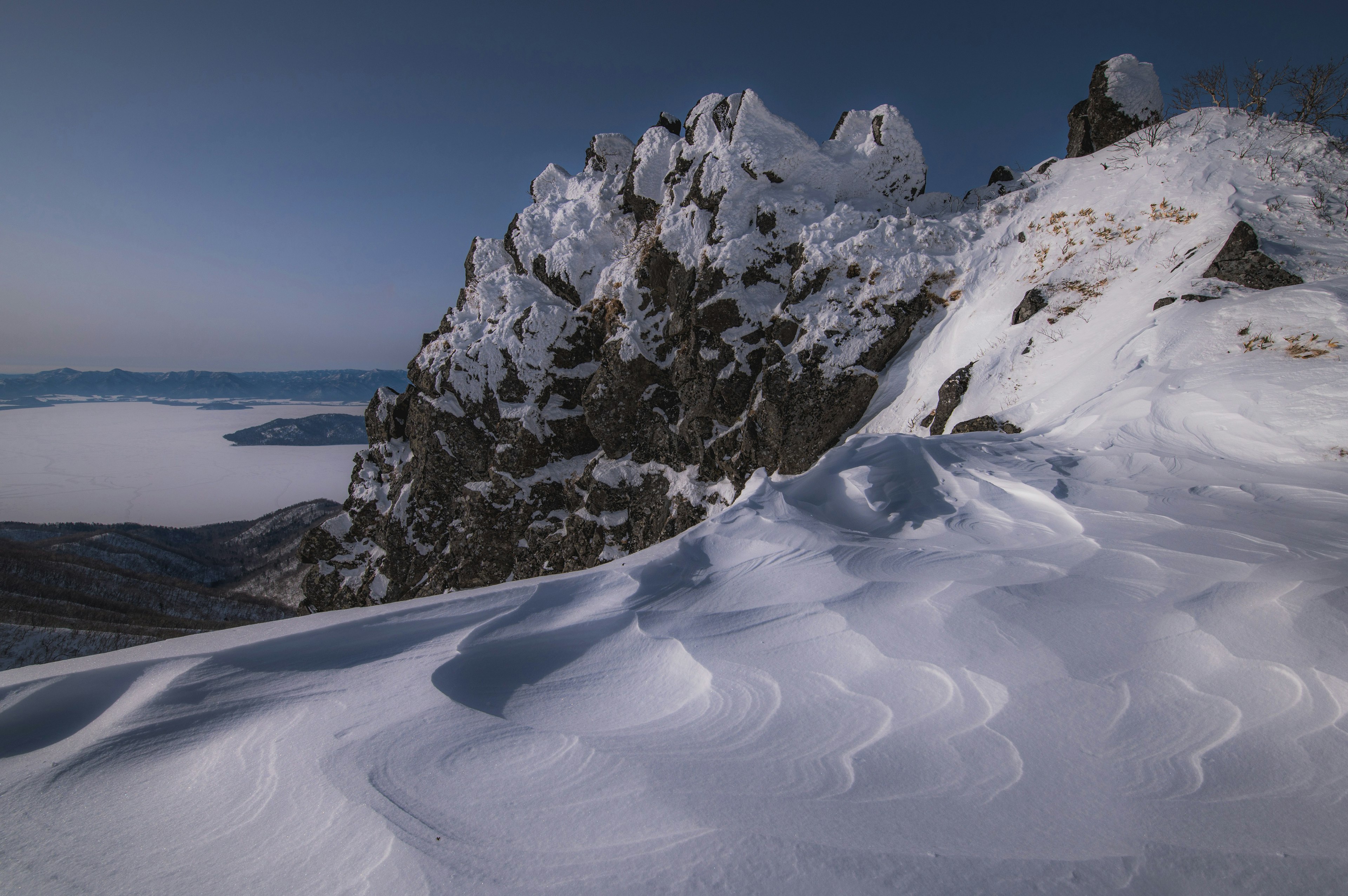 雪に覆われた岩山と滑らかな雪の斜面の風景